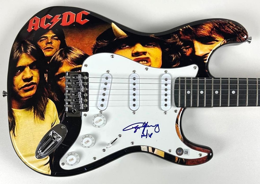 AC/DC: Angus Young Signed "Highway to Hell" Custom Graphics Stratocaster-Style Guitar (Beckett): "Highway to Hell" custom graphics Stratocaster-style guitar signed on the pickguard in blue felt tip marker by AC/DC band member Angus Young. Measuring approximately 39" x 17.5" and in fine condition.