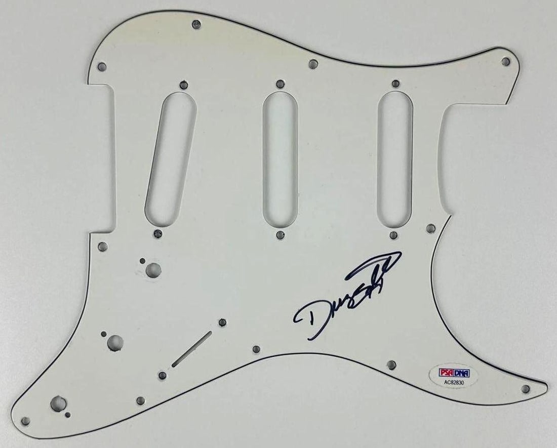 ZZ Top: Dusty Hill Signed Stratocaster-Style Pickguard (PSA/DNA Authentication): White 9" x 11" Stratocaster-style pickguard signed on the front in black felt tip marker by ZZ Top band member Dusty Hill. In fine condition. Accompanied by a PSA/DNA COA (#AC82830).