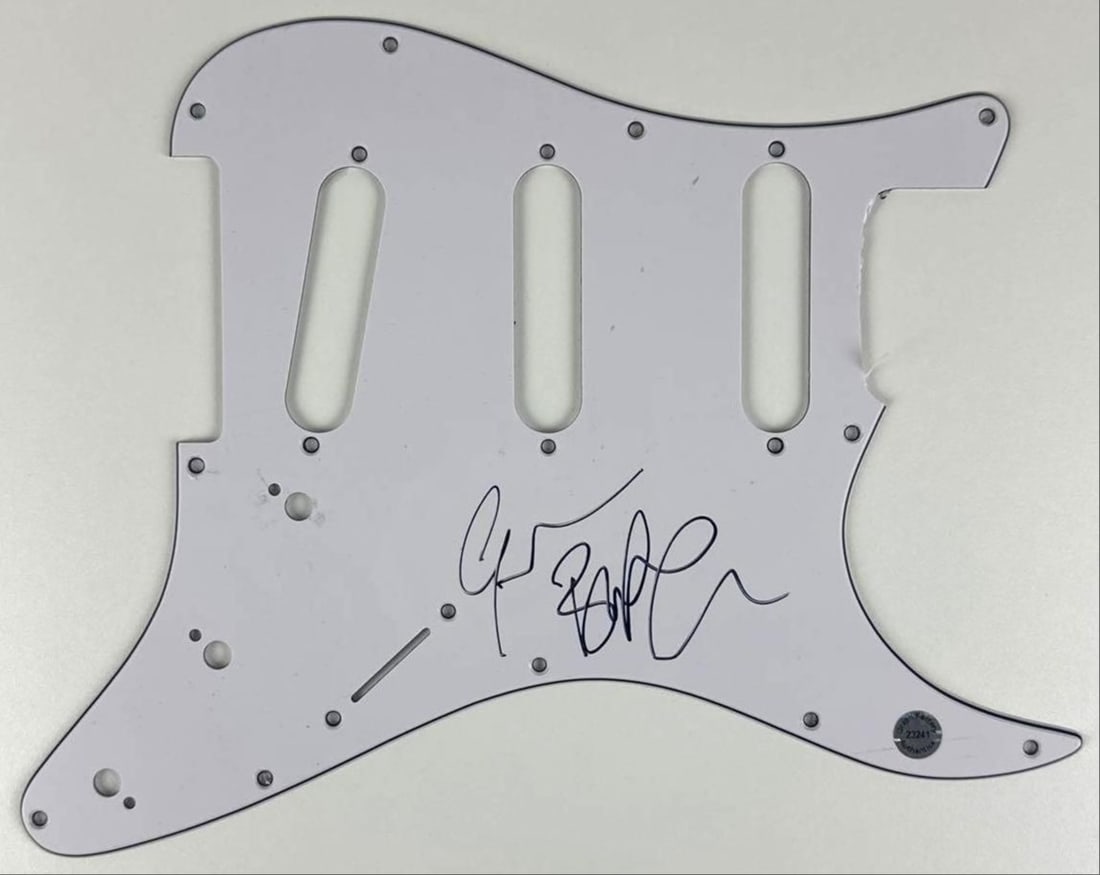 Black Sabbath: Geezer Butler Signed Stratocaster-Style Pickguard (Graph Factory Authentication): White 9" x 11" Stratocaster-style pickguard signed on the front in black felt tip marker by Black Sabbath band member Geezer Butler. In fine condition. Authenticated by Graph Factory, with their