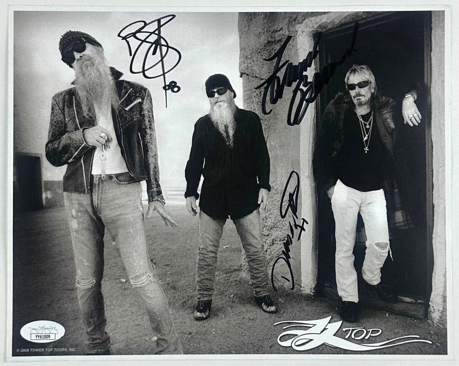 ZZ Top Group Signed 8" x 10" Photo (3 Sigs) (JSA Authentication): Black and white photo of rock band ZZ Top, signed by all three band members in black felt tip marker, including Billy Gibbons, Dusty Hill, and Frank Beard. Accompanied by a JSA sticker affixed to the