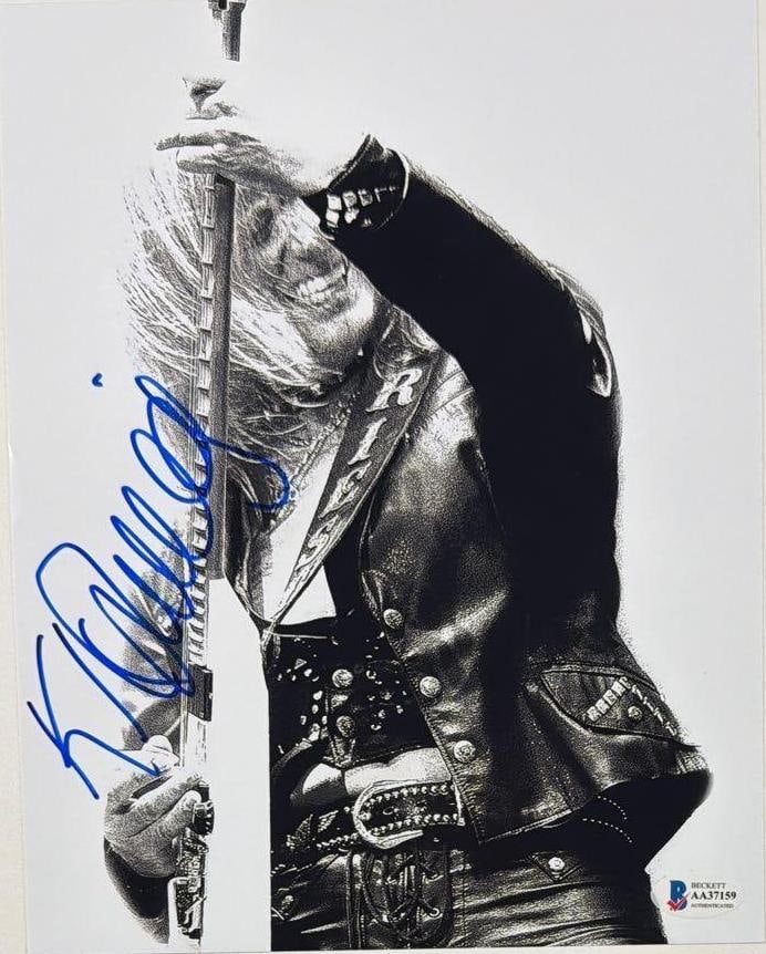 Judas Priest: K.K. Downing Signed 10" x 8" Photo (Beckett Authentication): Black-and-white 10" x 8" photo signed in blue felt tip marker by Judas Priest band member K.K. Downing. In fine condition. Authenticated by Beckett, with their offiical hologram affixed to the front