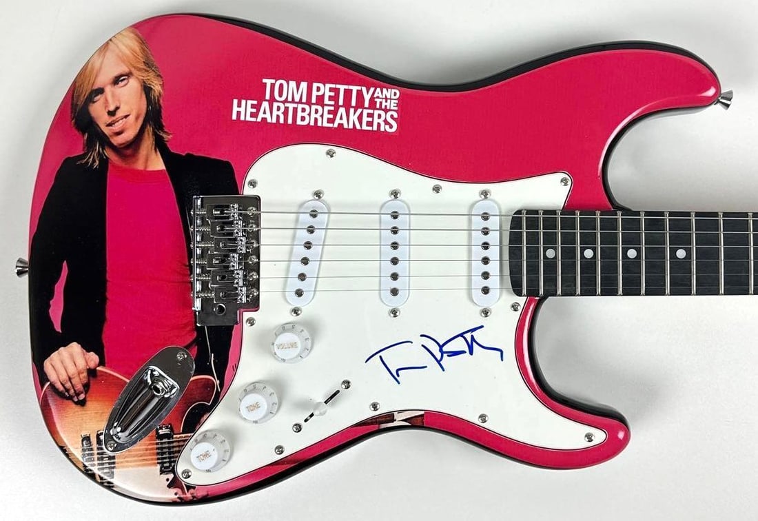Tom Petty Signed "Damn the Torpedoes" Graphics Stratocaster-Style Guitar (JSA Authentication): "Damn the Torpedoes" custom graphics Stratocaster-style guitar signed on the pickguard in blue felt tip marker by musician Tom Petty. Measuring approximately 39" x 13" and in fine condition. Accompani