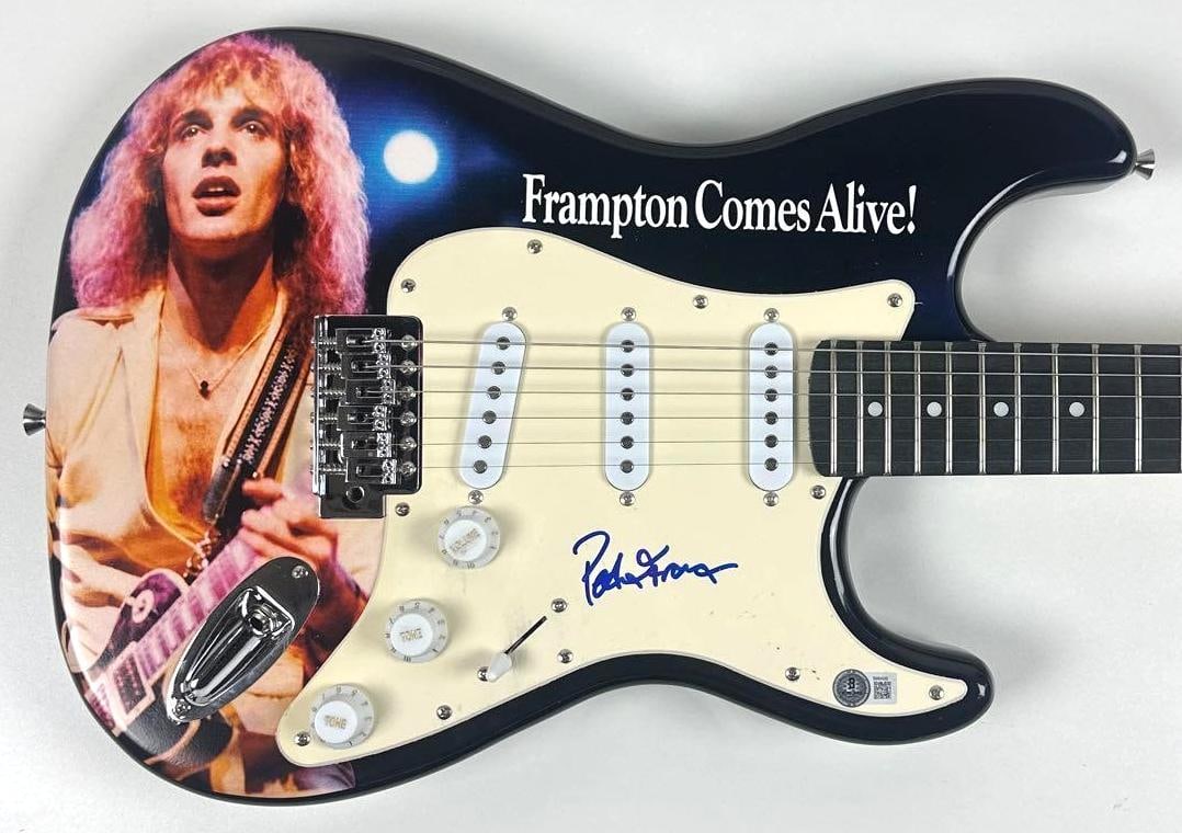 Peter Frampton Signed "Frampton Comes Alive" Custom Graphics Stratocaster-Style Guitar (Beckett): "Frampton Comes Alive" custom graphics Stratocaster-style guitar signed on the pickguard in blue felt tip marker by musician Peter Frampton. Measuring approximately 39" x 17.5" and in fine condition. 