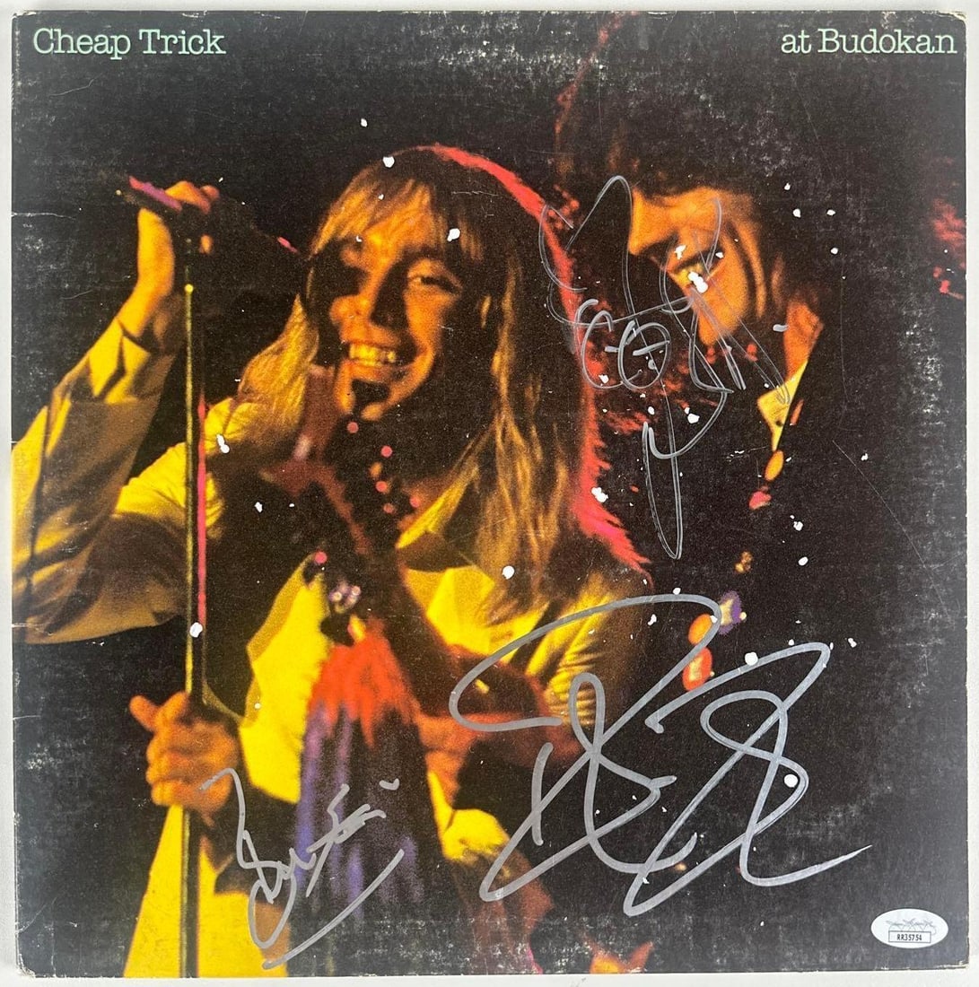 Cheap Trick Group Signed "At Budoken" Album (3 Sigs) (JSA Authentication): "At Budoken" album signed on the cover in silver felt tip marker by Cheap Trick band members Bun E. Carlos, Robin Zander, and Rick Nielsen. Measuring approximately 12" x 12" and in very good