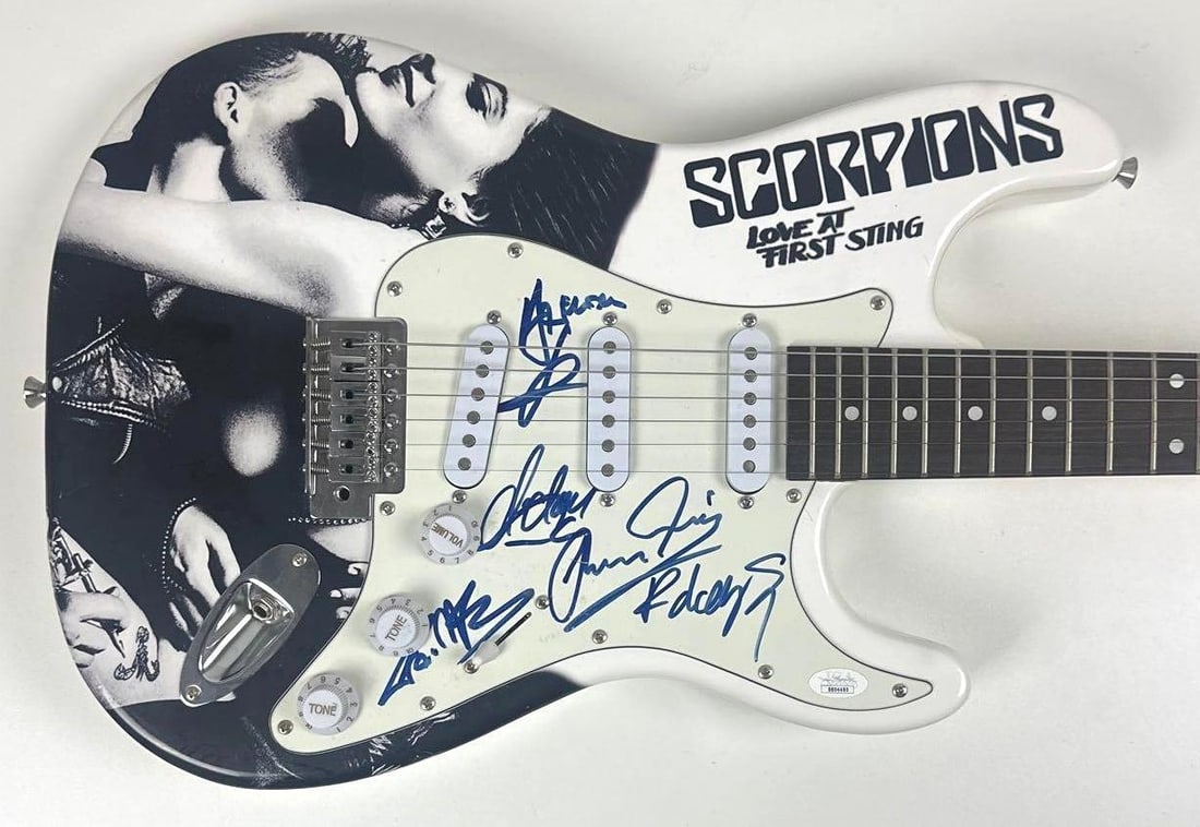 Scorpions Group Signed "Love at First Sting" Custom Graphics Strat-Style Guitar (5 Sigs) (JSA): "Love at First Sting" custom graphics Stratocaster-style electric guitar signed on the pickguard in blue felt tip marker by Scorpions band members Rudolf Schenker, Francis Buchholz, Klaus Meine,