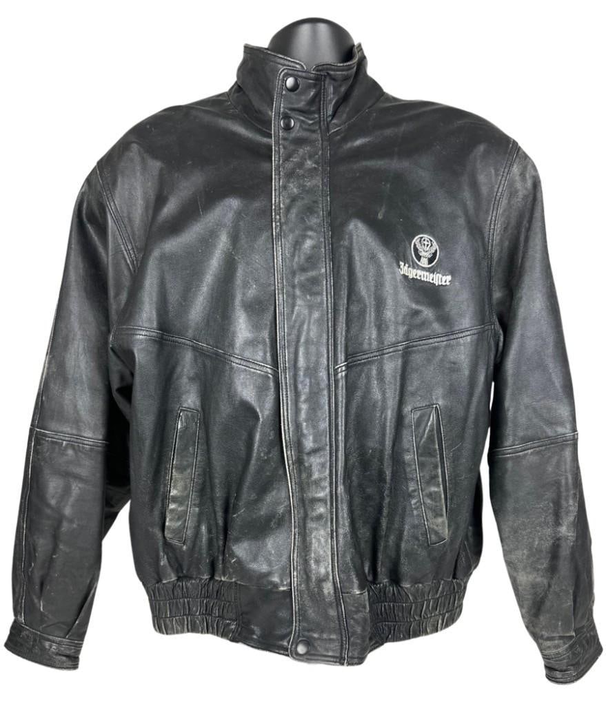 Jagermeister Leather Jacket (Chip Rachlin Collection): Original black large sized 27" x 25" leather jacket. The front left breast features the brand title "Jagermeister" and the small circular logo of a buck stitched in white. In very good condition,