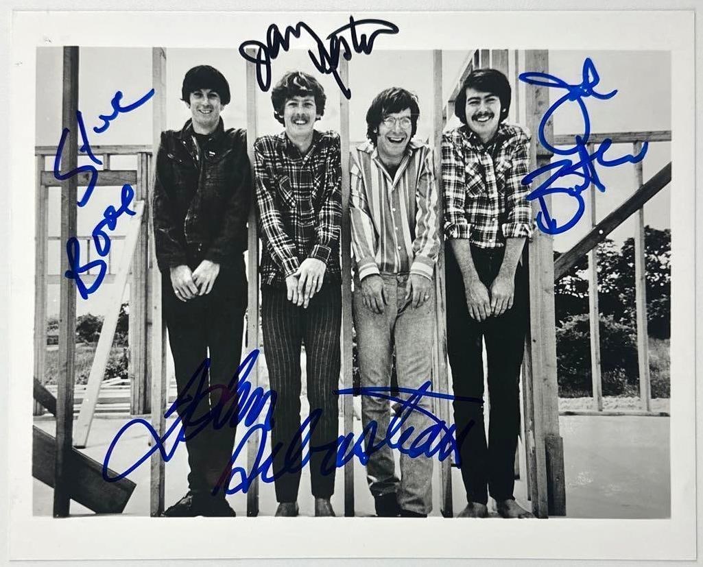 The Lovin' Spoonful Group Signed 8" x 10" Photo (4 Sigs) (JSA Authentication): Black-and-white 8" x 10" photo signed in blue and black felt tip markers by the Lovin' Spoonful band members John Sebastian, Steve Boone, Joe Butler, and Jerry Yestler. In fine condition.