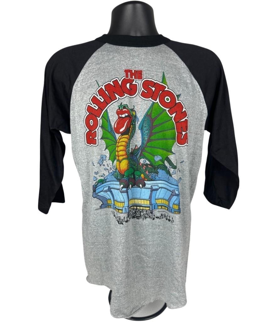 Rolling Stones Vintage 1981 Tour "Detroit" T-Shirt w/ Santana (Chip Rachlin Collection): Vintage original gray, blue, and red mens size XL 29.5" x 18.5" Rolling Stones concert t-shirt. The front features a colorful illustration of the band's iconic dragon logo sitting on top of a