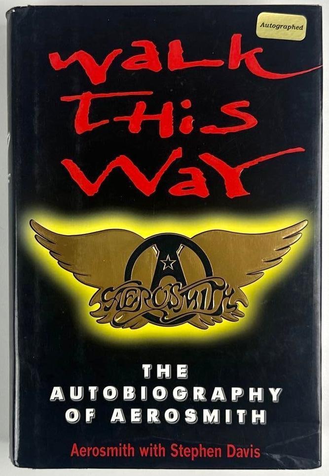 Aerosmith Fully Group Signed "Walk This Way" Autobiography Book (5 Sigs) (Beckett): Color hardcover 9.5" x 6.5" "Walk This Way: The Autobiography of Aerosmith" book signed on the inside front page in black ballpoint pen by Aerosmith band members Joe Perry, Joey Kramer, Steven Tyler, 
