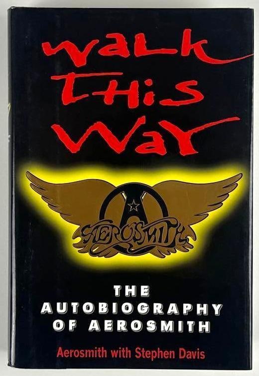 Aerosmith Fully Group Signed "Walk This Way" Autobiography Book (5 Sigs) (Beckett): Color hardcover 9.5" x 6.5" "Walk This Way: The Autobiography of Aerosmith" book signed on the inside front page in black ballpoint pen by Aerosmith band members Steven Tyler, Joey Kramer, Brad Whitfo