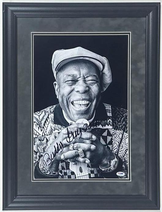 Buddy Guy Signed 18" x 12" Photo Framed Display (PSA/DNA Authentication): Black-and-white 18" x 12" photo signed in black felt tip marker by musician Buddy Guy. Signed photo measures 18" x 12" and is displayed in a frame measuring 19" x 25" overall. Authenticated by