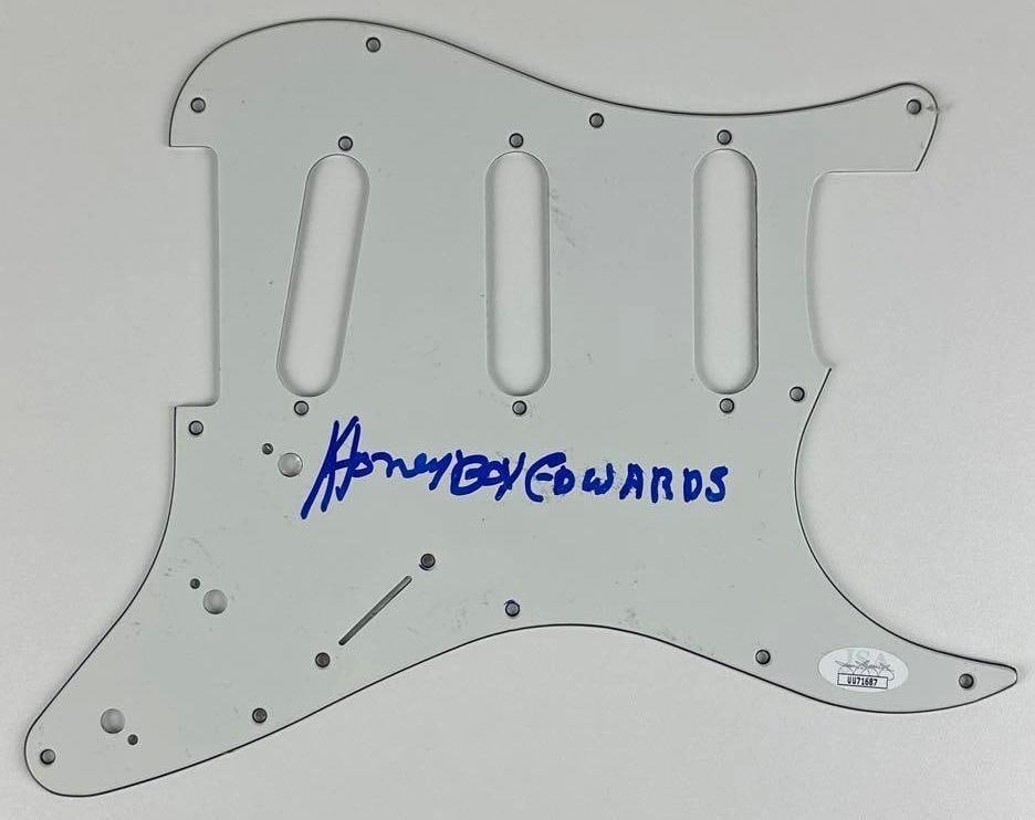 Honeyboy Edwards Signed Stratocaster-Style Pickguard (JSA Authentication): White 9" x 11" Stratocaster-style pickguard signed on the front in blue felt tip marker by musician Honeyboy Edwards. In fine condition. Accompanied by a JSA COA (#UU71687) and a full Letter of
