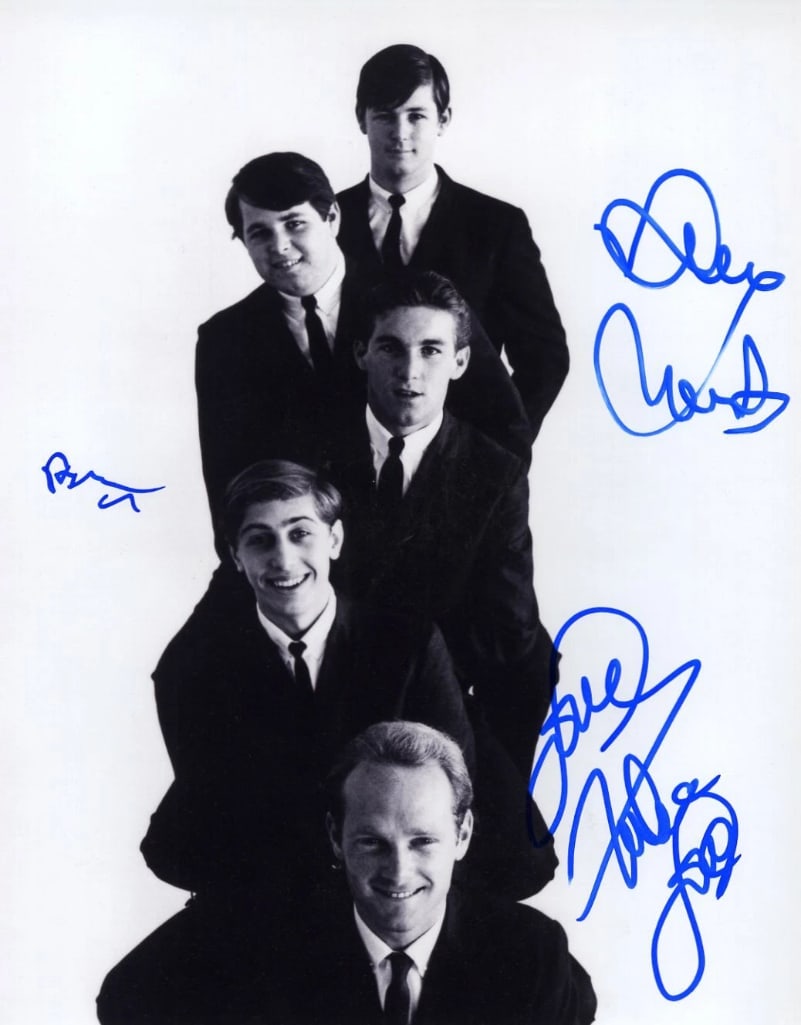 The Beach Boys Group Signed 14" x 11" Promo Photo (3 Sigs) (Third Party Guaranteed): Black-and-white 14" x 11" promotional photo signed in blue felt tip marker by the Beach Boys band members Brian Wilson, Mike Love, and David Marks. In fine condition. Provenance Eaton & Brennan