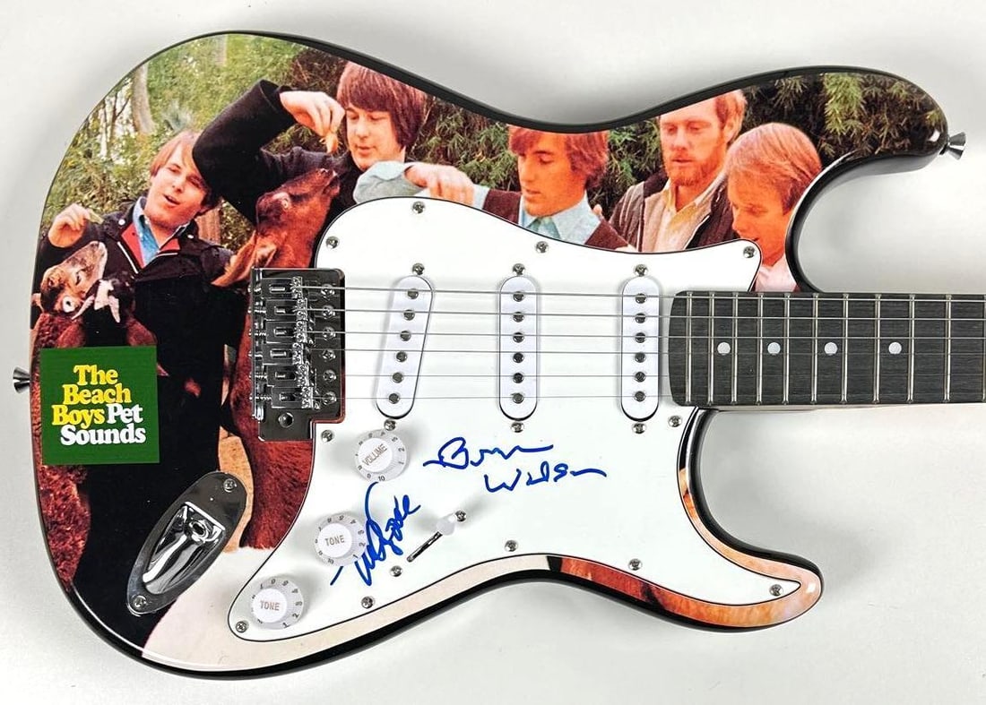 Beach Boys: Brian Wilson & Mike Love Signed "Pet Sounds" Guitar (2 Sigs) (JSA): "Pet Sounds" custom graphics Stratocaster-style guitar signed on the pickguard in blue felt tip marker by the Beach Boys band members Brian Wilson and Mike Love. Measuring approximately 39" x 17.5"
