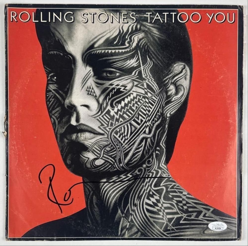 Rolling Stones: Ron Wood Signed "Tattoo You" Album (JSA Authentication): "Tattoo You" album signed on the cover in black felt tip marker by Rolling Stones guitarist Ron Wood. Measuring approximately 12" x 12" and in good condition with noticeable edge and spine wear.