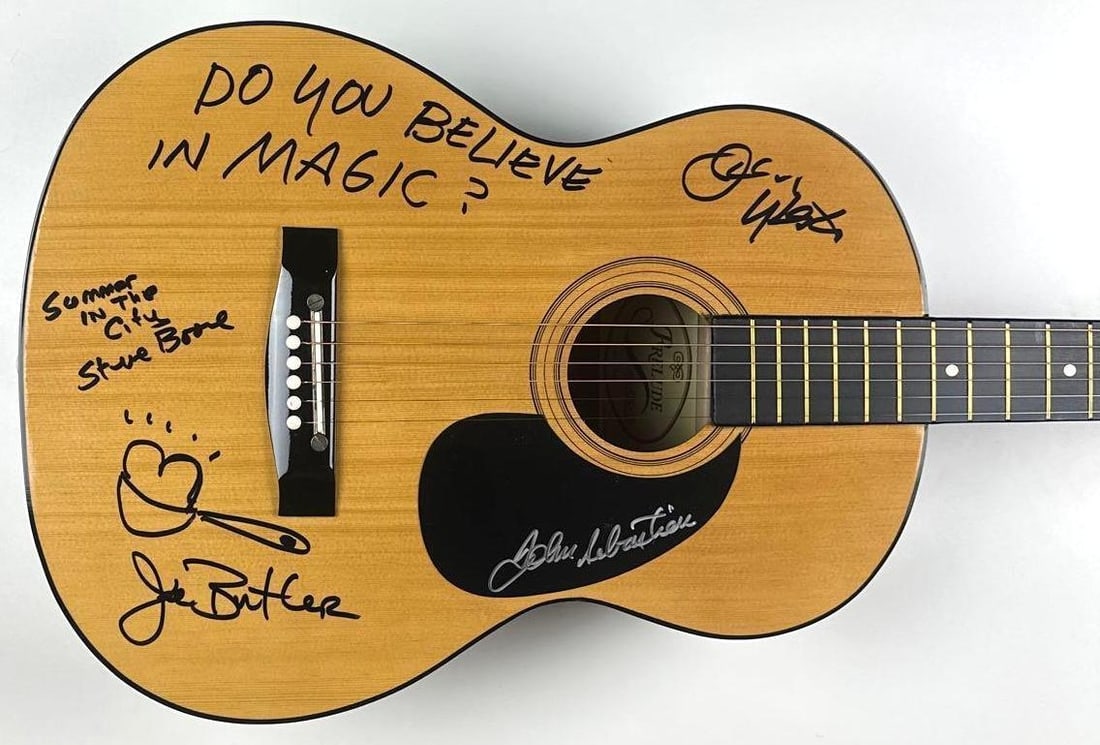 The Lovin' Spoonful Group Signed Acoustic Guitar (4 Sigs) (Walls of Sound): Wooden Prelude brand acoustic guitar signed on the body and pickguard in black and silver felt tip markers by The Lovin' Spoonful band members Jerry Yester, who inscribed "Do you believe in magic"