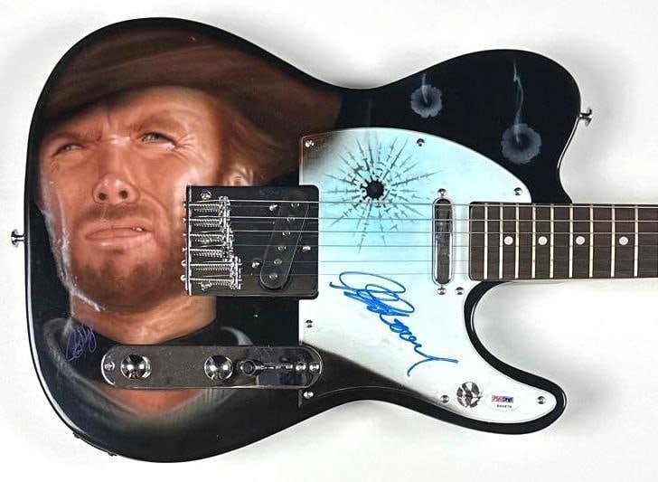The Good, the Bad, & the Ugly: Clint Eastwood Signed Custom Graphics Tele-Style Guitar (PSA/DNA): "The Good, the Bad, & the Ugly" custom graphics Telecaster-style guitar signed on the body in blue felt tip marker by director and actor Clint Eastwood. Measuring approximately 39" x 13" and in fine
