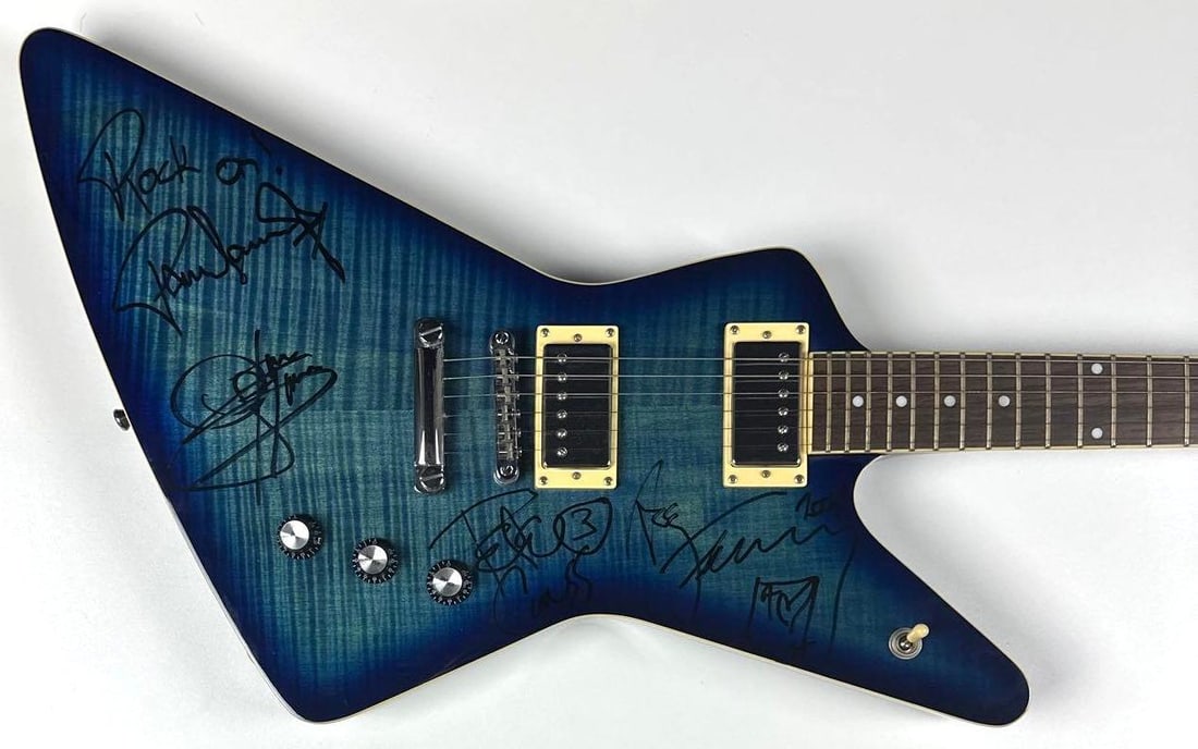 KISS Group Signed Hurricane Brand Custom Series Explorer-Style Guitar (4 Sigs) (PSA/DNA): Ocean sunburst Hurricane Custom Series Explorer-style electric guitar, signed prominently on the body in black felt-tip marker by all four original members of KISS: Gene Simmons, Paul Stanley, Ace Fre