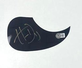 Hardy Signed Teardrop Pickguard (Beckett Authentication): Black teardrop shape pickguard signed in gold felt tip marker by musician Hardy. In fine condition. Authenticated by Beckett, with their official hologram affixed to the front bottom right corner
