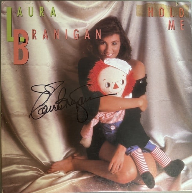 Laura Branigan Signed "Hold Me" LP Album (Epperson LOA): "Hold Me" LP album signed on the cover in black felt tip marker by musician Laura Branigan. Measuring approximately 12" x 12" and in very good condition, with some signs of scattered wear, not affecti
