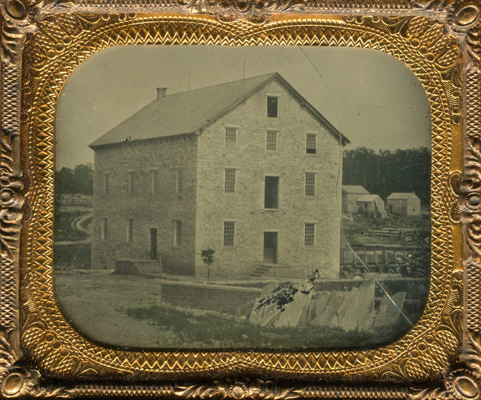 Ambrotype of a Stone Building with Graves Stones: A sixth plate ambrotype housed in a full case that intriguingly captures what appears to be a newly constructed building, possibly indicating the disturbance of a graveyard. The evidence lies in the h