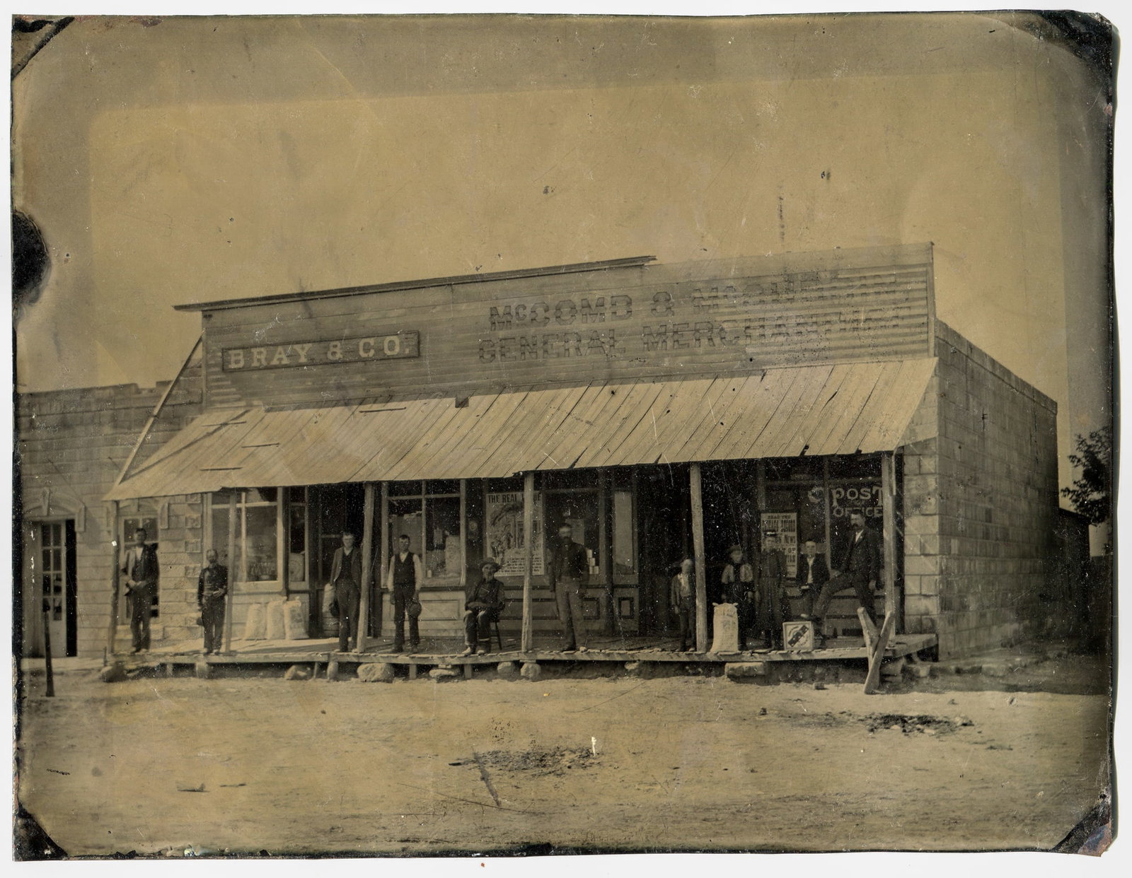 Full Plate Tintype of Webster, Kansas with Lots of Signs: A captivating full plate tintype richly adorned with an assortment of signs, prominently showcasing Bray & Co, McComb & McCubbin General Merchant, and the Post Office. The scene is further enhanced by