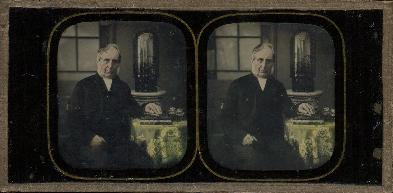 Tinted Stereo Ambrotype of a Man Sitting at a Table: A captivating tinted stereoview ambrotype by Charles Ravis of Bristol, featuring a distinguished man seated at a table. The careful hand-tinting brings the scene to life, highlighting the intricate de