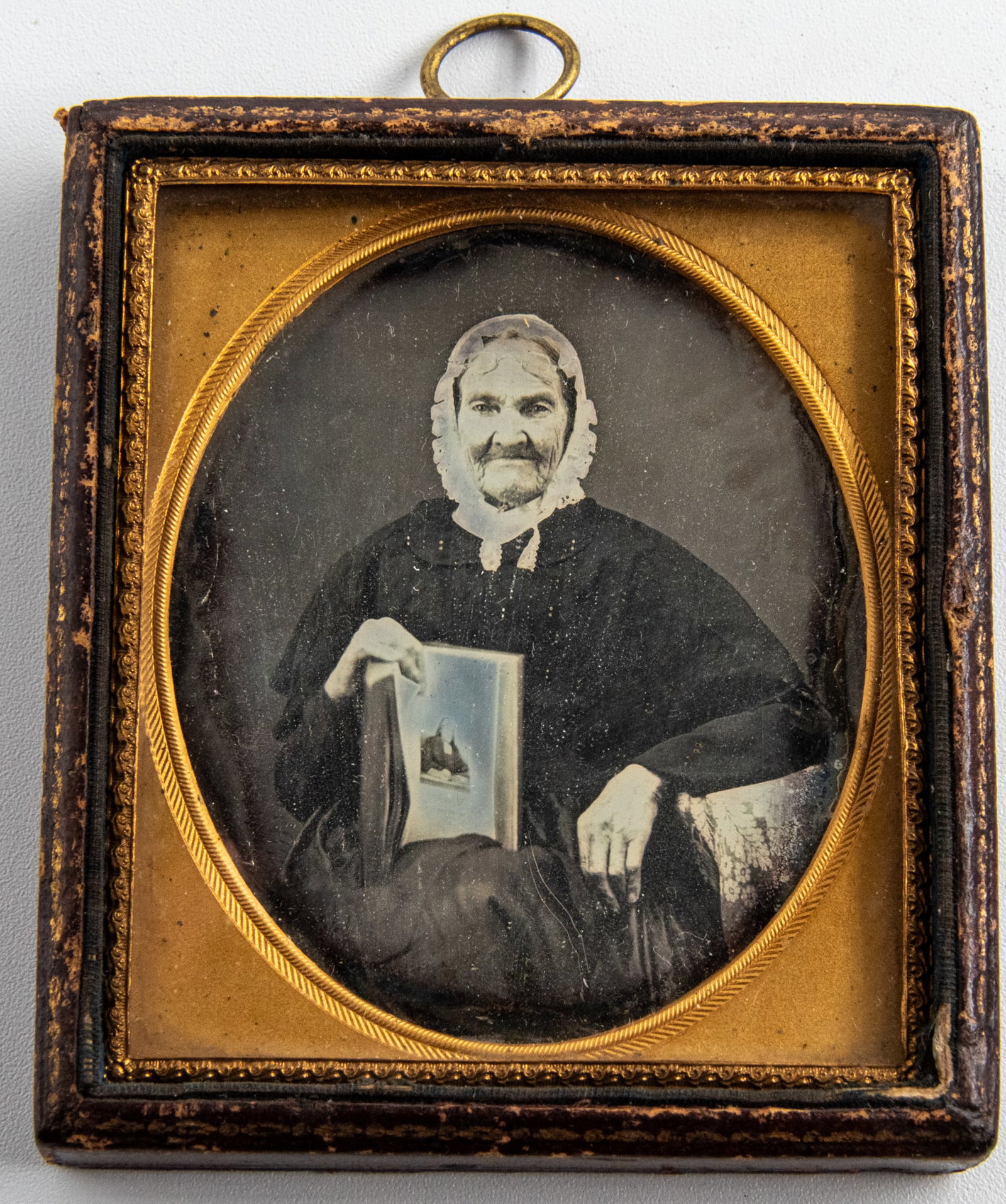 Daguerreotype of Older Woman with Glasses and Open Book: In this exquisite daguerreotype, the older woman exudes a sense of learned grace, her glasses perched on her forehead suggesting a momentary pause from reading. The open book in her hands reveals page