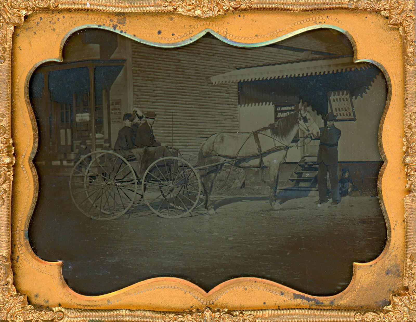 Ambrotype of a Horse and Cart in Front of a Photographer's Studio: A charming quarter plate ambrotype capturing a family in their horse-drawn cart, set against the backdrop of a photographer's studio adorned with images on the outside wall. In this delightful image,