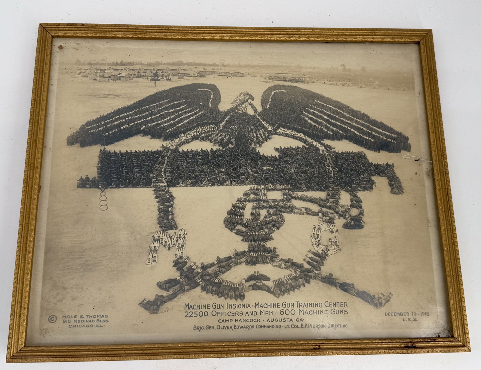 Mole & Thompson Machine Gun Insignia: An extraordinary framed photograph by Mole & Thomas, showcasing a massive human formation of the Machine Gun Insignia, created using 22,500 officers and men alongside 600 machine guns. This iconic ima