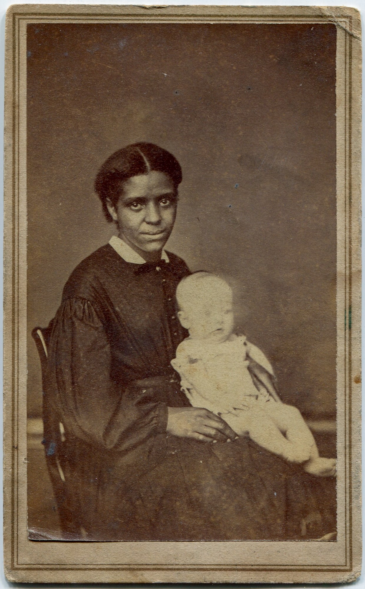 CDV of a African American Woman Holding an infant: A poignant and historically significant carte de visite depicting an African American woman holding a Caucasian infant, captured by Isbell & Wilson, photographers at No. 275 Main Street, Bridgeport, C