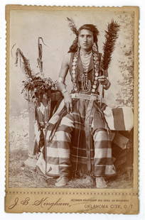 Cabinet Card of Native American Warrior – Oklahoma Territory: Exceptional and vivid cabinet card photograph of a Native American warrior, richly attired in full ceremonial regalia. His beadwork, concho breastplate, necklaces, and earrings are beautifully visible