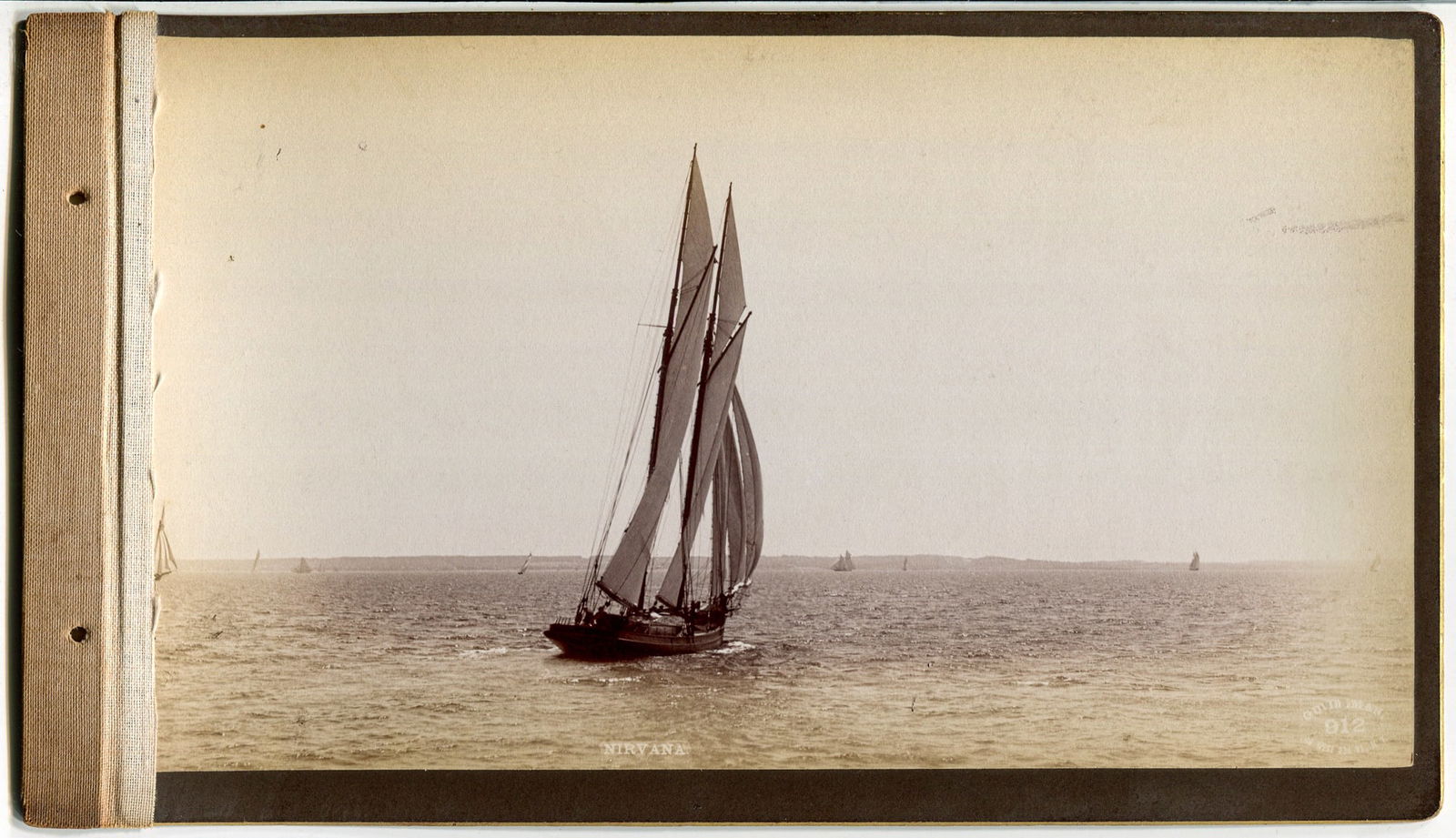 Boudoir Card Photograph of Yacht Nirvana Under Sail: Handsome boudoir card photograph showing the racing schooner Nirvana slicing through the water, heeled over on a tack with sails full. The vessel is crisply captured from the stern quarter as she lean
