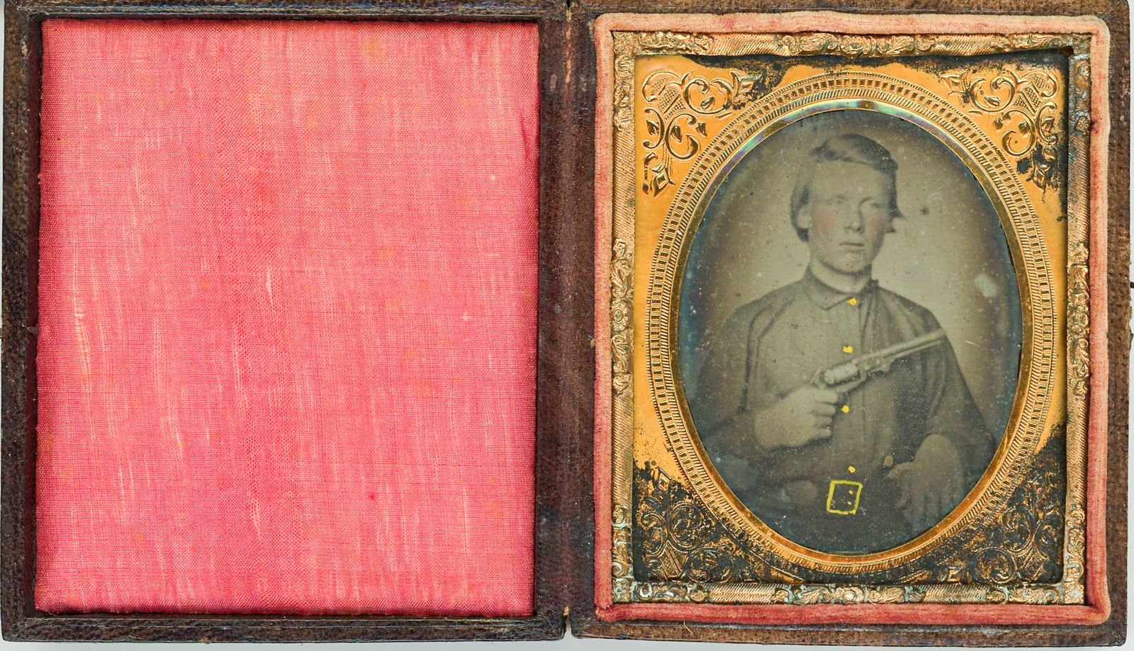 Sixth Plate Ambrotype of Armed Confederate Soldier with Revolver: Sixth plate ambrotype portrait of an unidentified Confederate Civil War soldier, posed three-quarter length and holding a percussion revolver prominently across his chest. The subject wears civilian c