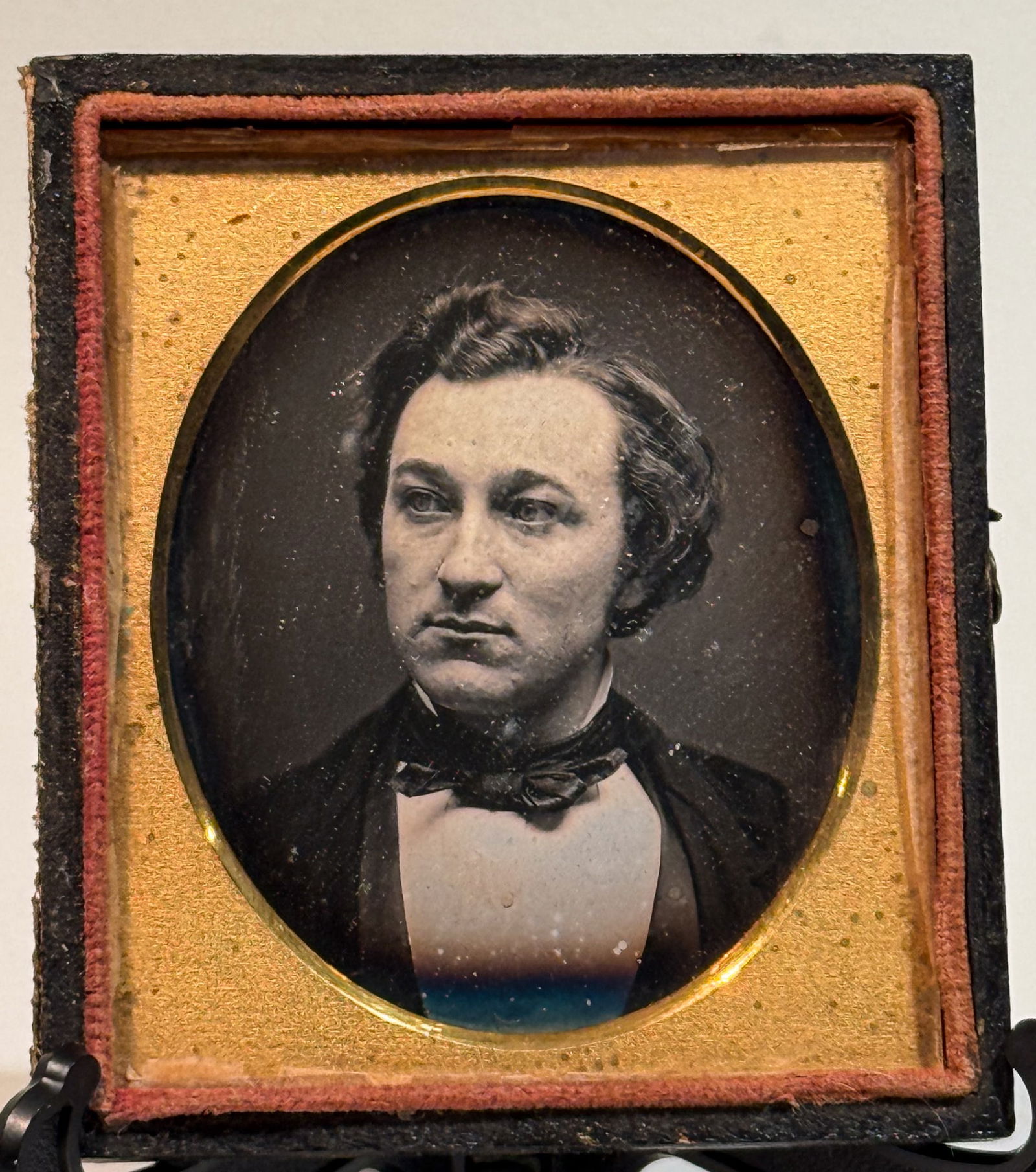 Daguerreotype Portrait of a Young Man in Bow Tie, Three-Quarter View: Sixth-plate daguerreotype portrait depicting a young man posed in three-quarter view, looking slightly off to the side rather than directly at the camera. He wears a dark coat, light waistcoat, and a