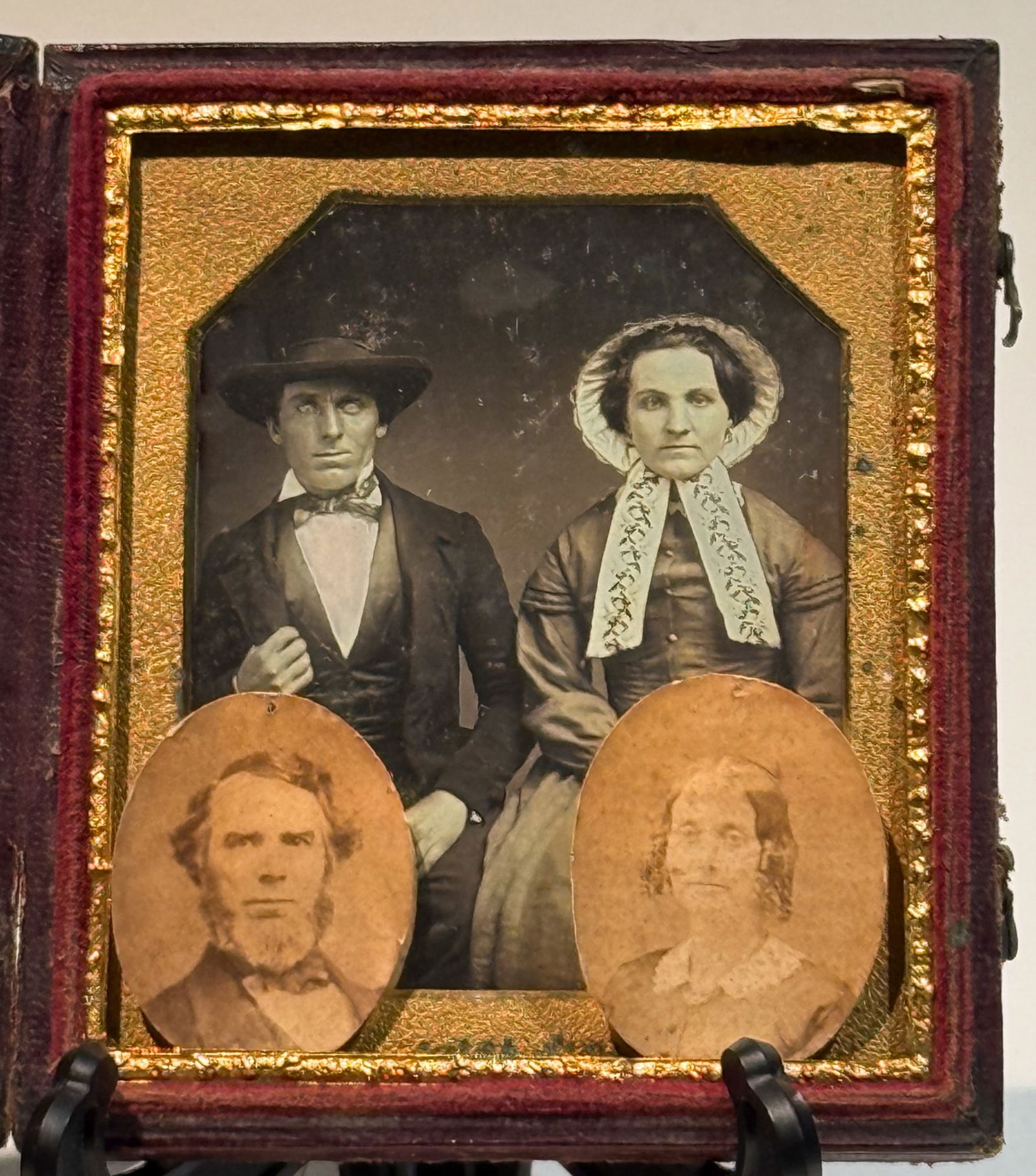 Daguerreotype of Seated Couple with Later Albumen Portraits: Daguerreotype portrait of an unidentified seated couple, housed in a hinged case, with two small albumen photographs of the same individuals at an older age affixed within the presentation. The primar