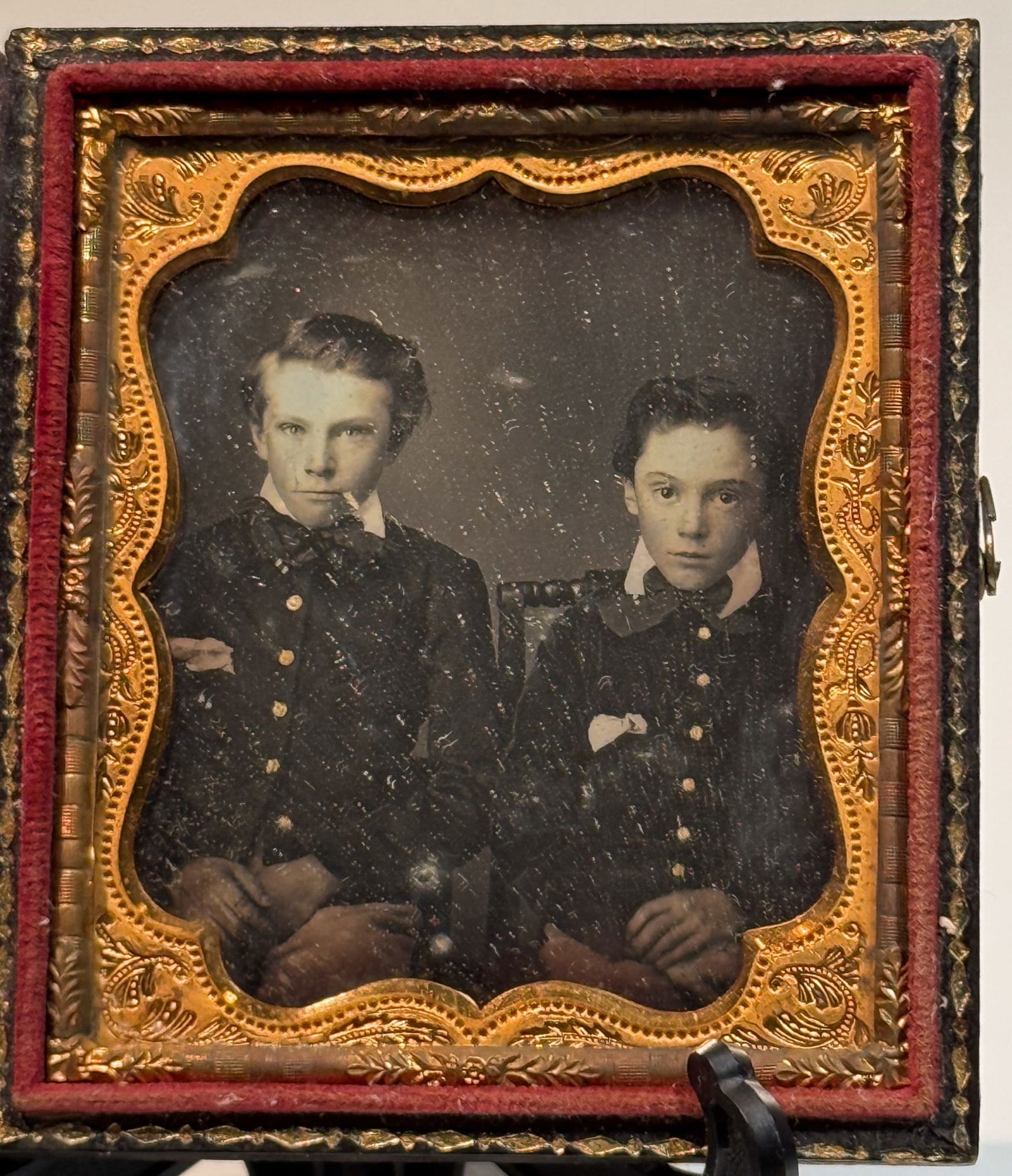 Daguerreotype Portrait of Two Young Siblings: Sixth plate daguerreotype portrait depicting two young children seated side by side, likely siblings, posed formally and facing the camera. Both wear dark buttoned garments with crisp white collars, t