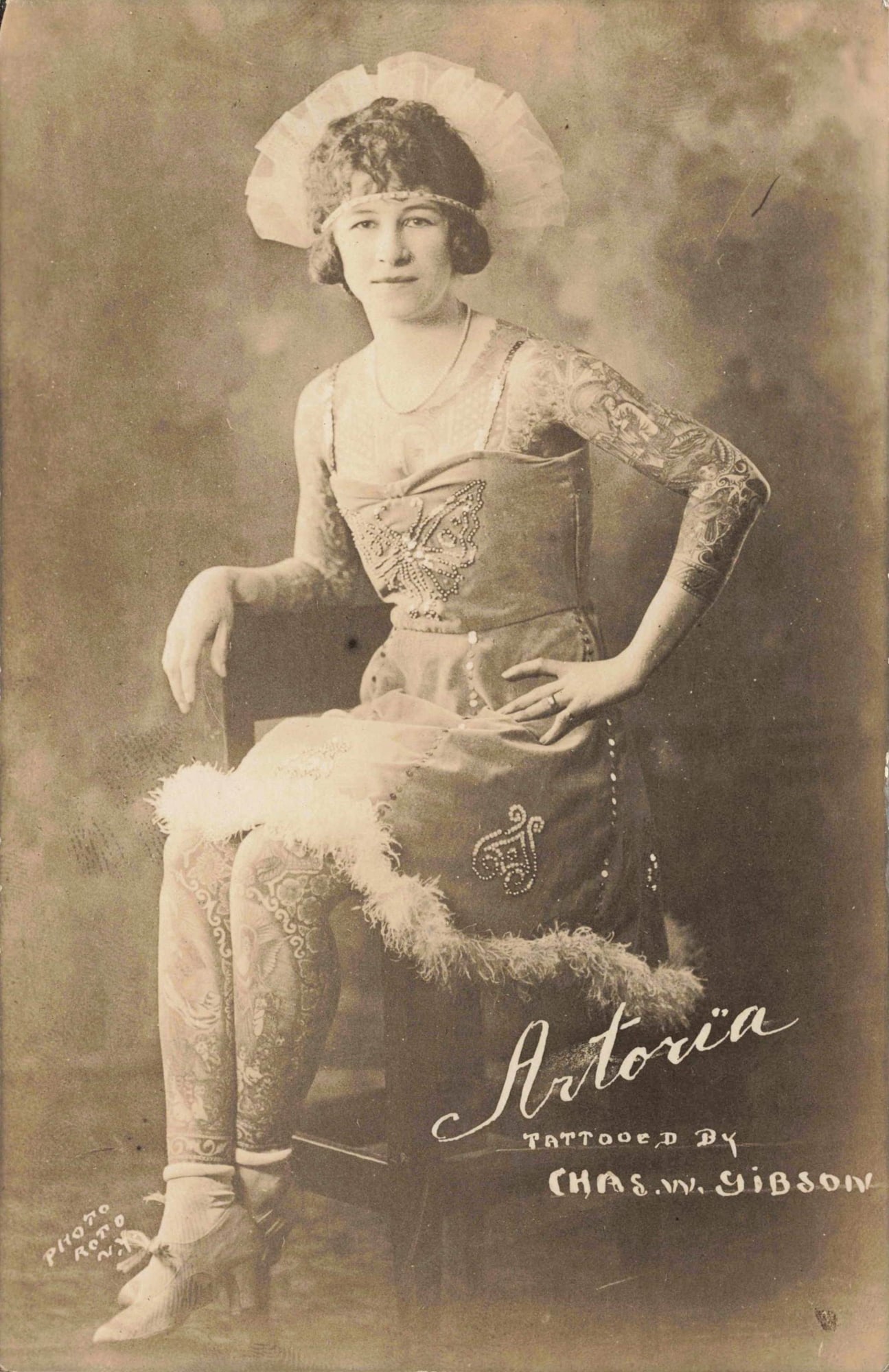 RPPC Astoria Tattooed by Chas. W. Gibson: Real photo postcard featuring “Astoria,” with the printed credit “Tattooed by Chas. W. Gibson” visible on the image. Publisher or photographer credit “Photo Auto by Rano” appea