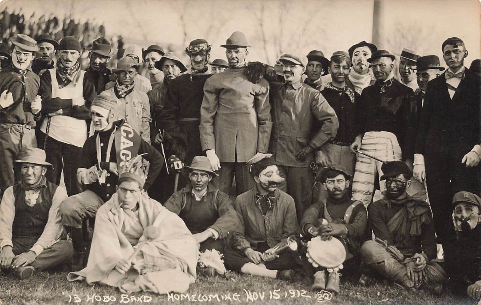 RPPC “Hobo Band?? Homecoming 1912 Postcard: Real photo postcard group portrait labeled “Hobo Band Homecoming Nov 15 1912.” The reverse is printed as Strauch’s Student Life Series, University of Illinois, Champaign-Urbana. A large grou