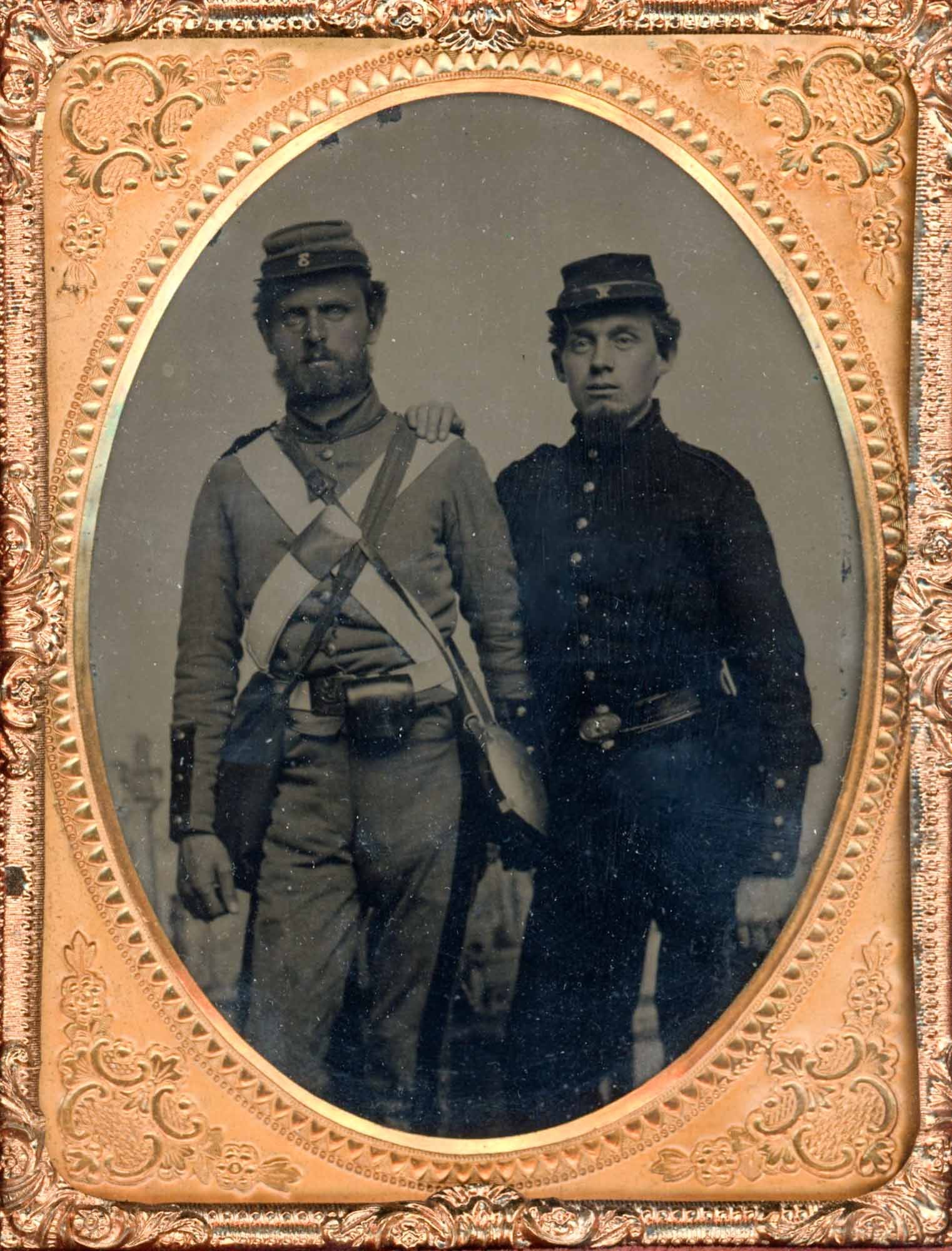 Tintype, Two Civil War Soldiers, Swords, Quarter Plate: Two unidentified Union soldiers stand together in this quarter plate tintype, housed in an embossed gilt frame with an oval mat bearing a beaded inner border and floral corner ornaments. The image dat