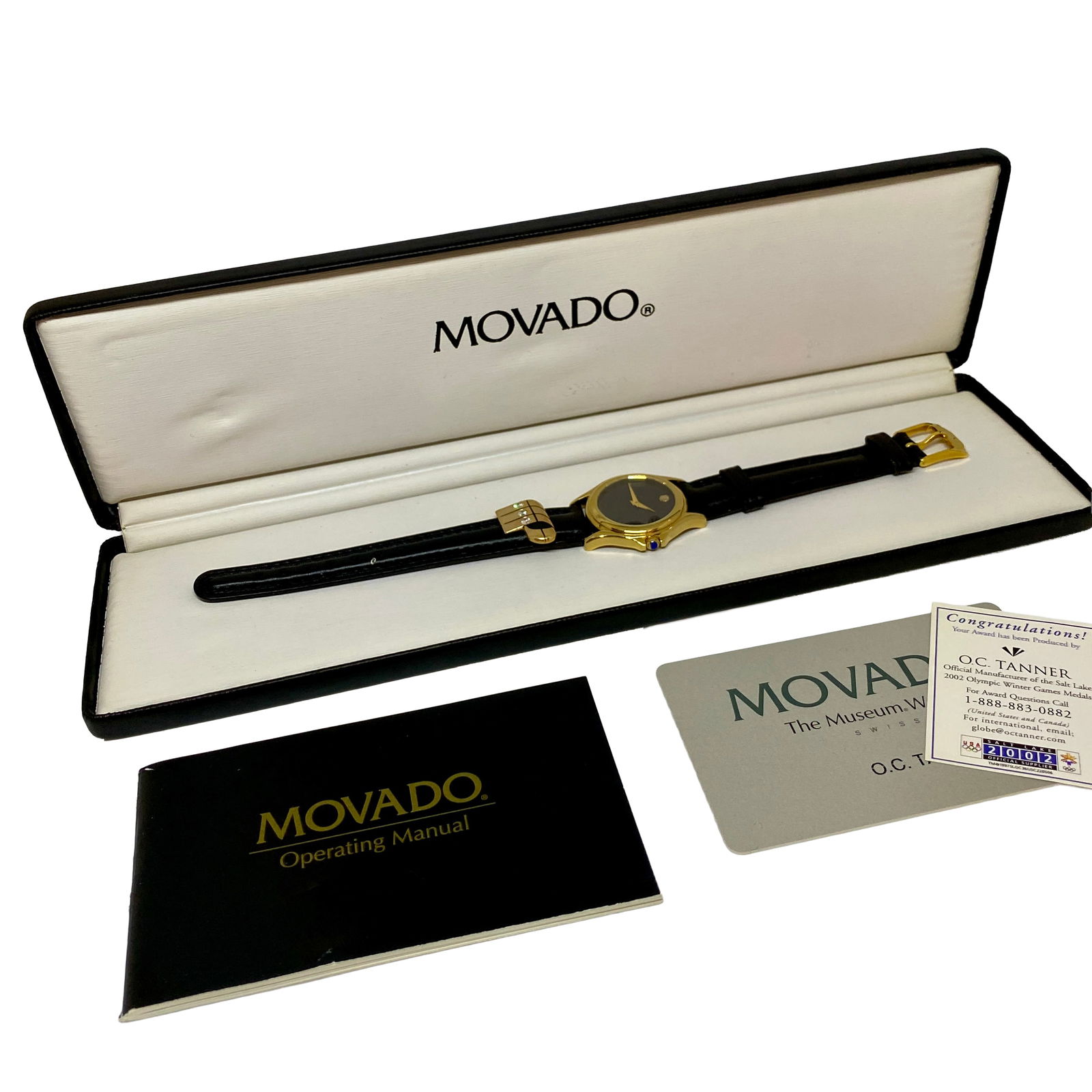 Movado Museum 2002 Watch: Movado “Museum” 2002 wristwatch featuring the signature black dial with single gold-tone dot, gold-tone case, and black leather strap. Includes original Movado presentation box, operating manu