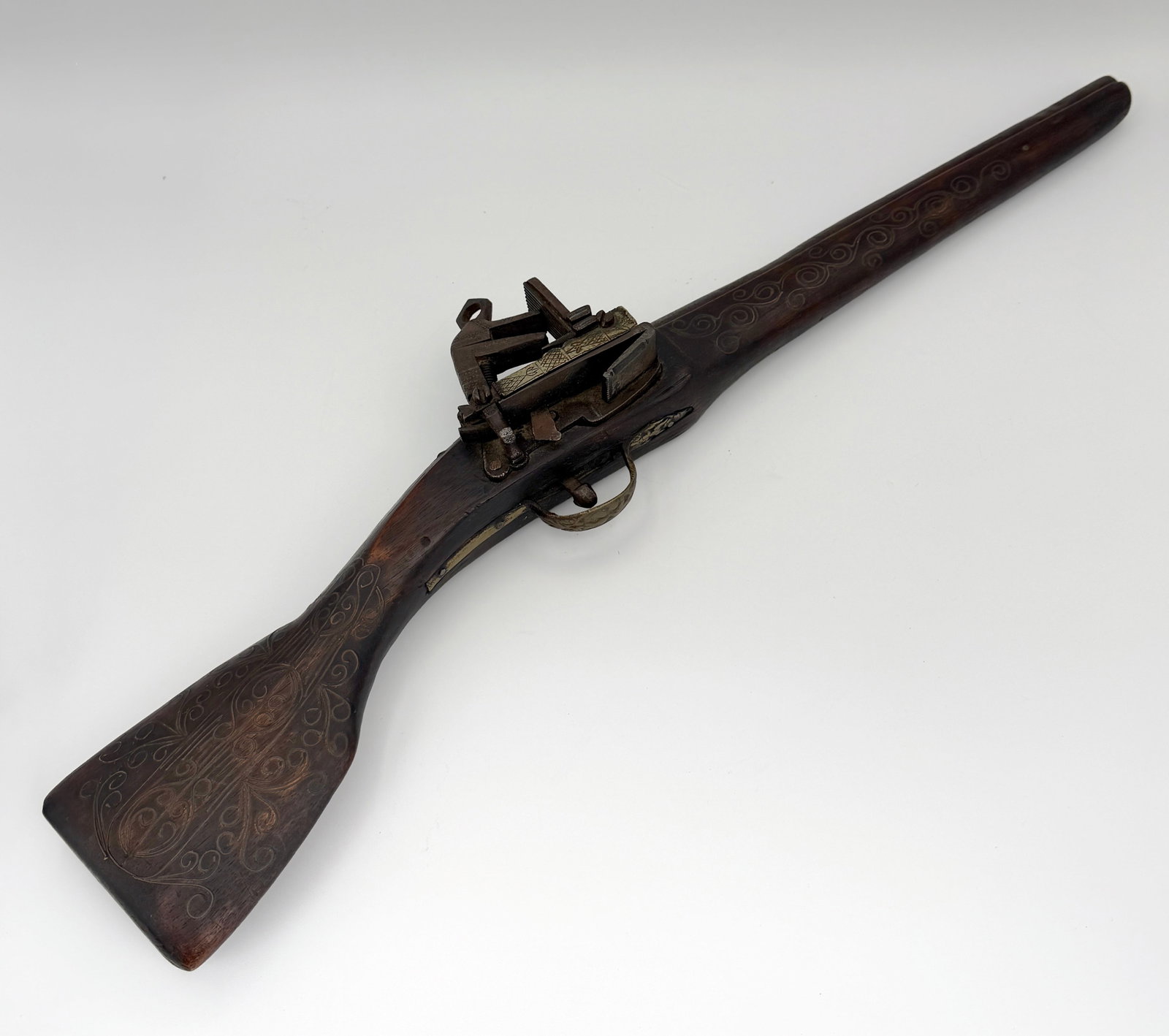 19th Century Spanish Carbine Decorative Replica: Antique nonfiring Spanish 19th century style miquelet carbine replica. Detailed carved wood stock decorated with silver scroll inlay and etched embellishments on the flintlock miquelet.