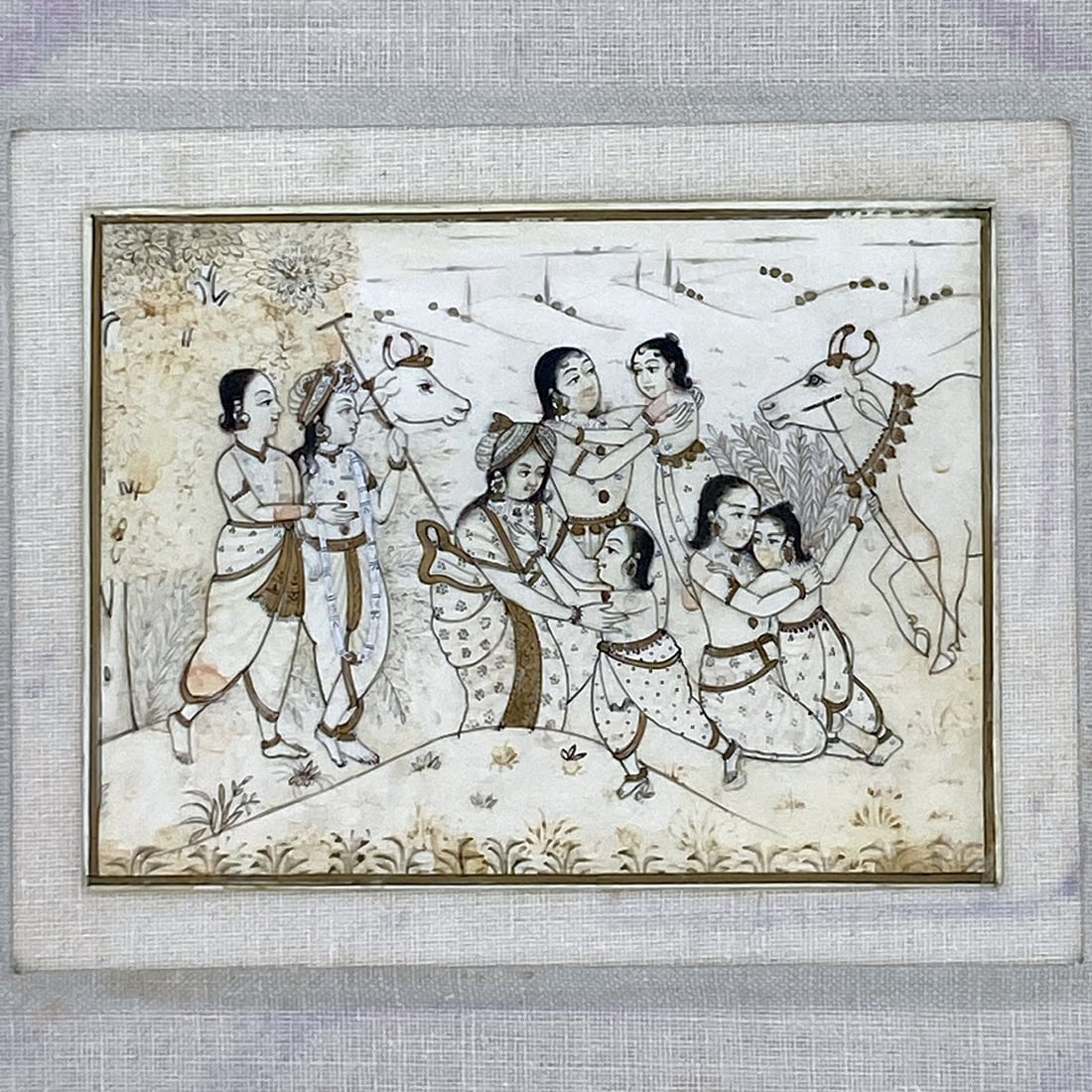 Women & Children Pastoral Mughal Miniature Painting: Mughal-style miniature painting depicting a group of women and children interacting in a pastoral setting with cows and landscape elements in the background. The figures are rendered in the
