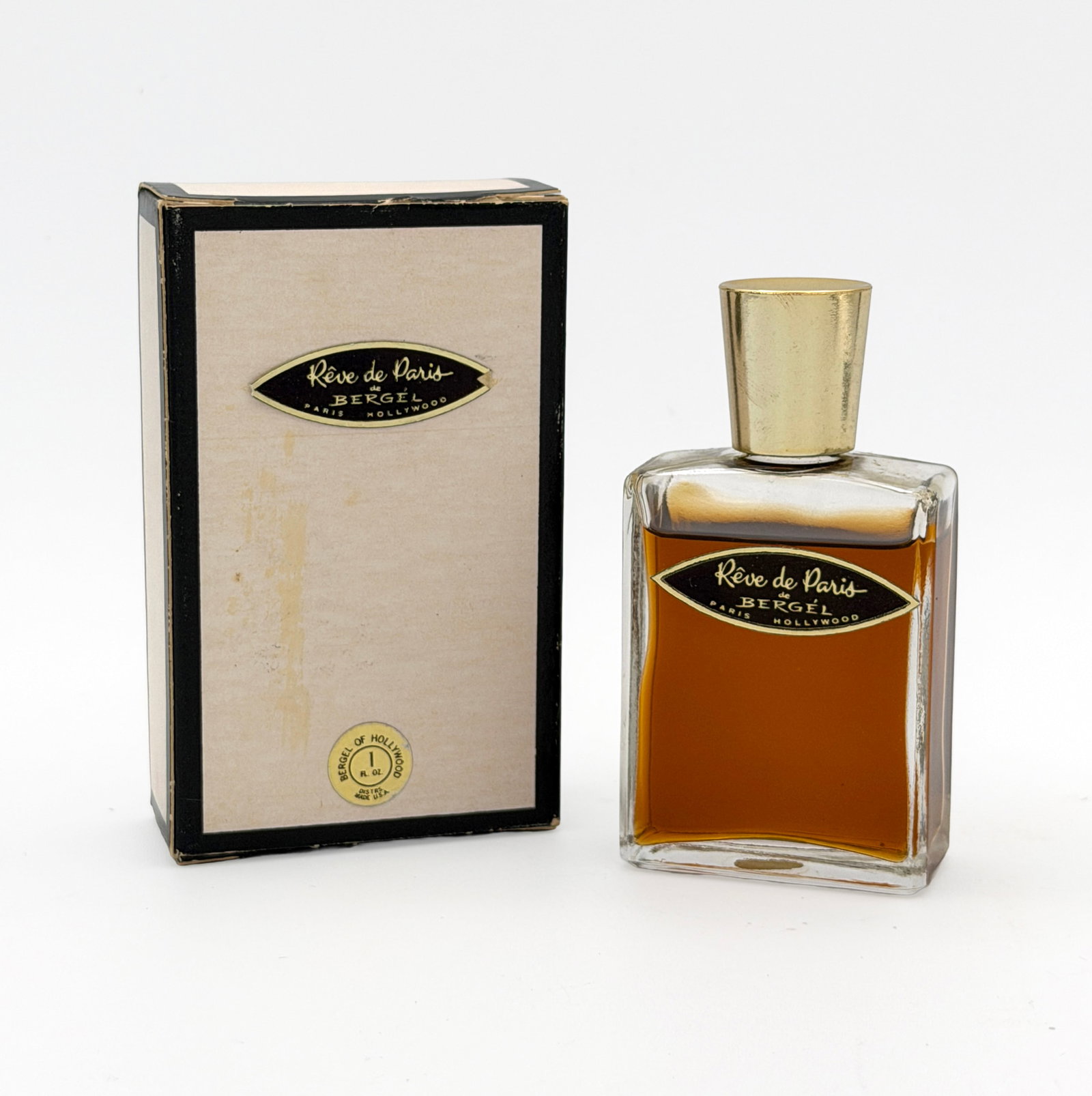Vintage Reve de Paris perfume 1 fl oz: Vintage Reve de Paris perfume by Bergel of Hollywood - ~0.8 fl oz new in box. Opened bottle, scant usage. Standard white box with black outline variant, gold sticker affixed to bottom.