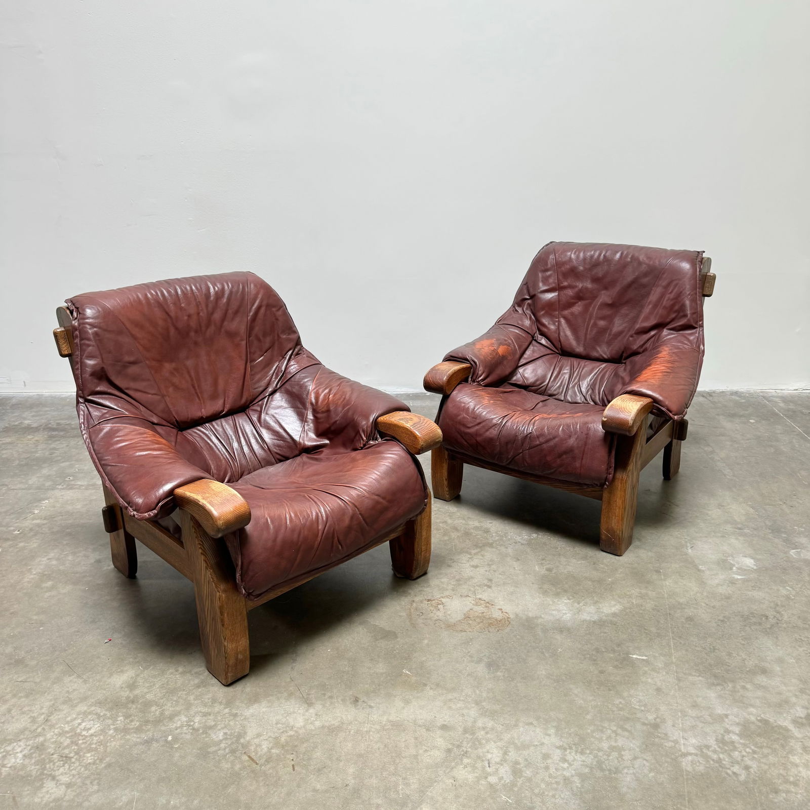 Pair of French Provincial Armchairs in Leather, France 1960s: Extremely comfortable pair of French provincial armchairs in the style of Pierre Chapo in solid oak and leather. Height: 33.8" Width: 37" Depth: 31.5" Seat Height: 16.5"