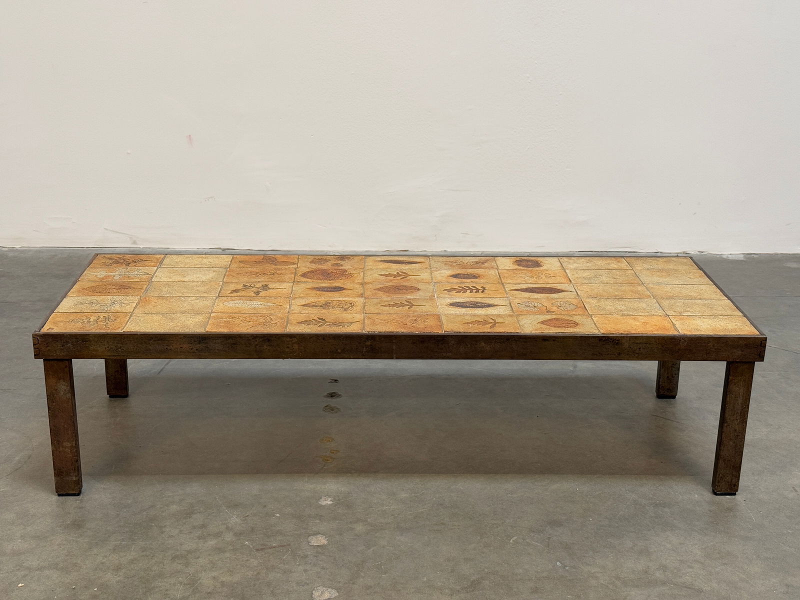 Roger Capron Large Iron Frame Garrigue Coffee Table: Remarkable coffee table by Roger Capron, featuring a robust iron frame and ceramic tile top with his signature garrigue design. Height: 12 in. Width: 46 in. Depth: 17 in.