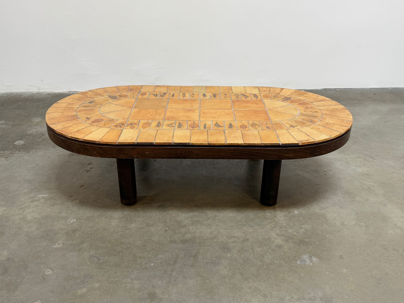 Roger Capron Round Ceramic Coffee Table: Vintage round coffee table by Roger Capron, showcasing his signature ceramic tile work with intricate natural motifs. Height: 13 in. Length: 53 in. Width: 29 in.