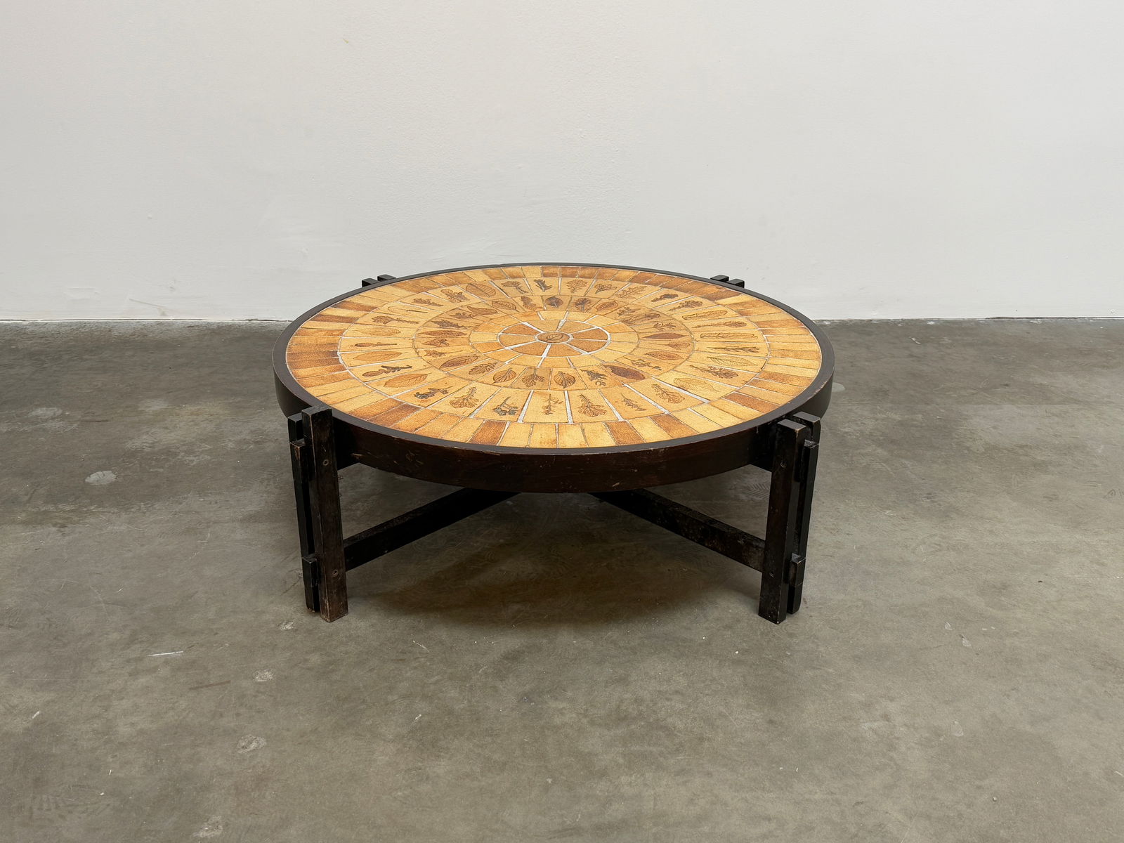 Roger Capron Round Ceramic Coffee Table: Vintage round coffee table by Roger Capron, showcasing his signature ceramic tile work with intricate natural motifs. Height: 14 in. Width: 53 in. Depth: 29 in.