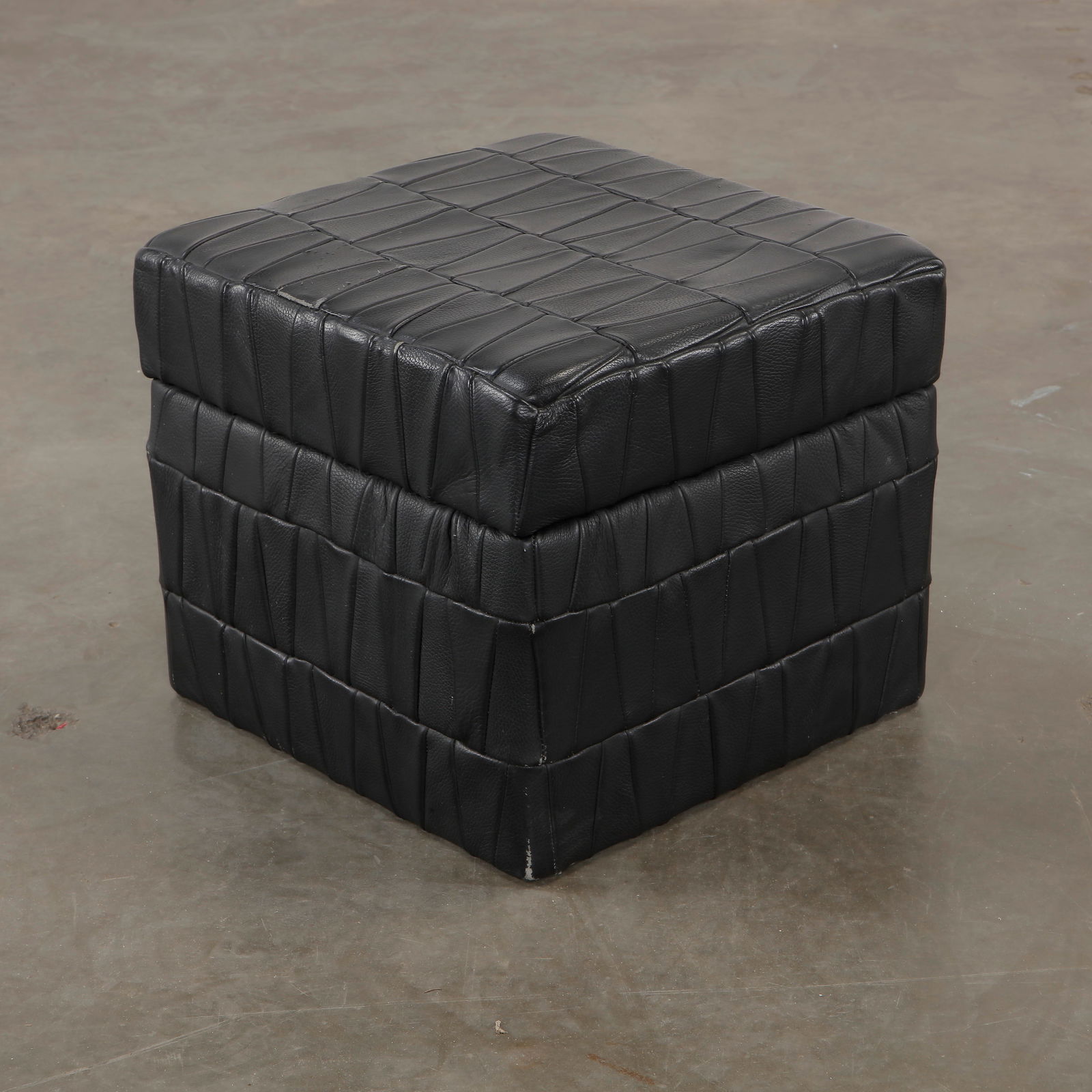 Patchwork Leather Storage Ottoman by De Sede, 1970s: A unique ottoman by De Sede, upholstered in stitched black leather patchwork. Functional and sculptural, it doubles as a storage unit. Height: 14 in. Width: 16 in. Depth: 17 in.