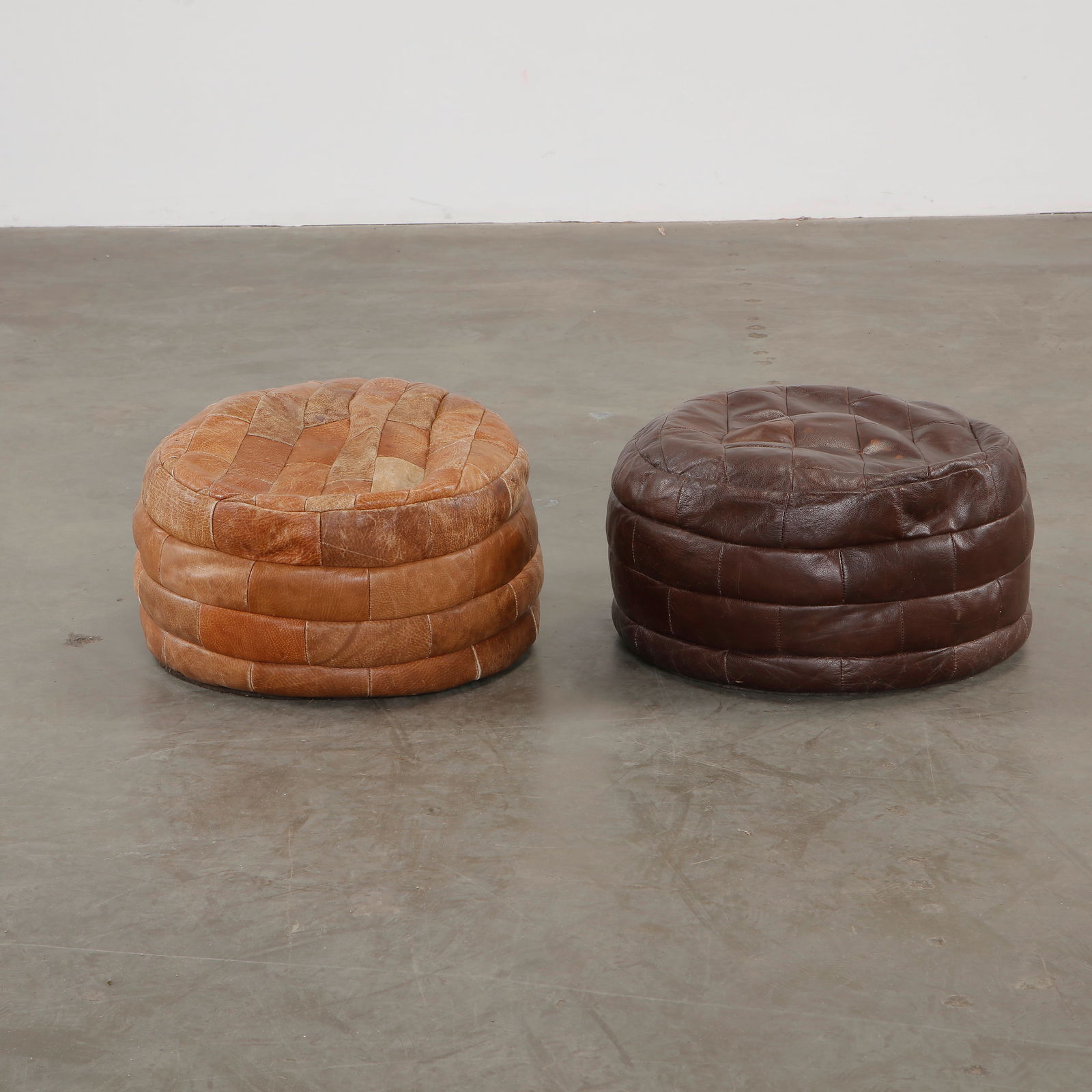 Pair of Leather De Sede Ottomans, 1970s: A luxurious pair of De Sede ottomans, upholstered in premium leather with a supple, sculptural form. Height: 15 in. Width: 20 in. Depth: 20 in.